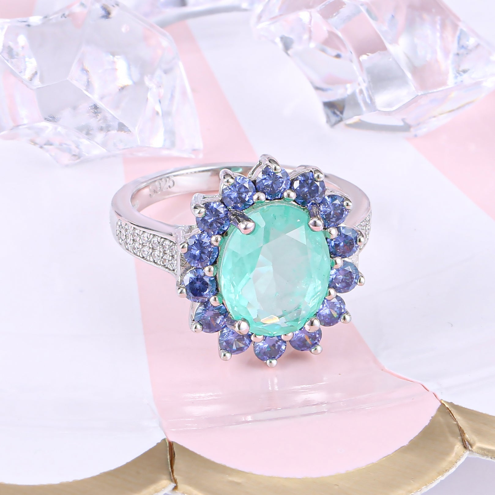 A beautiful Brazilian created blue tourmaline Paraiba halo ring set in 925 sterling silver with a white gold finish, showcasing a vibrant blue stone.