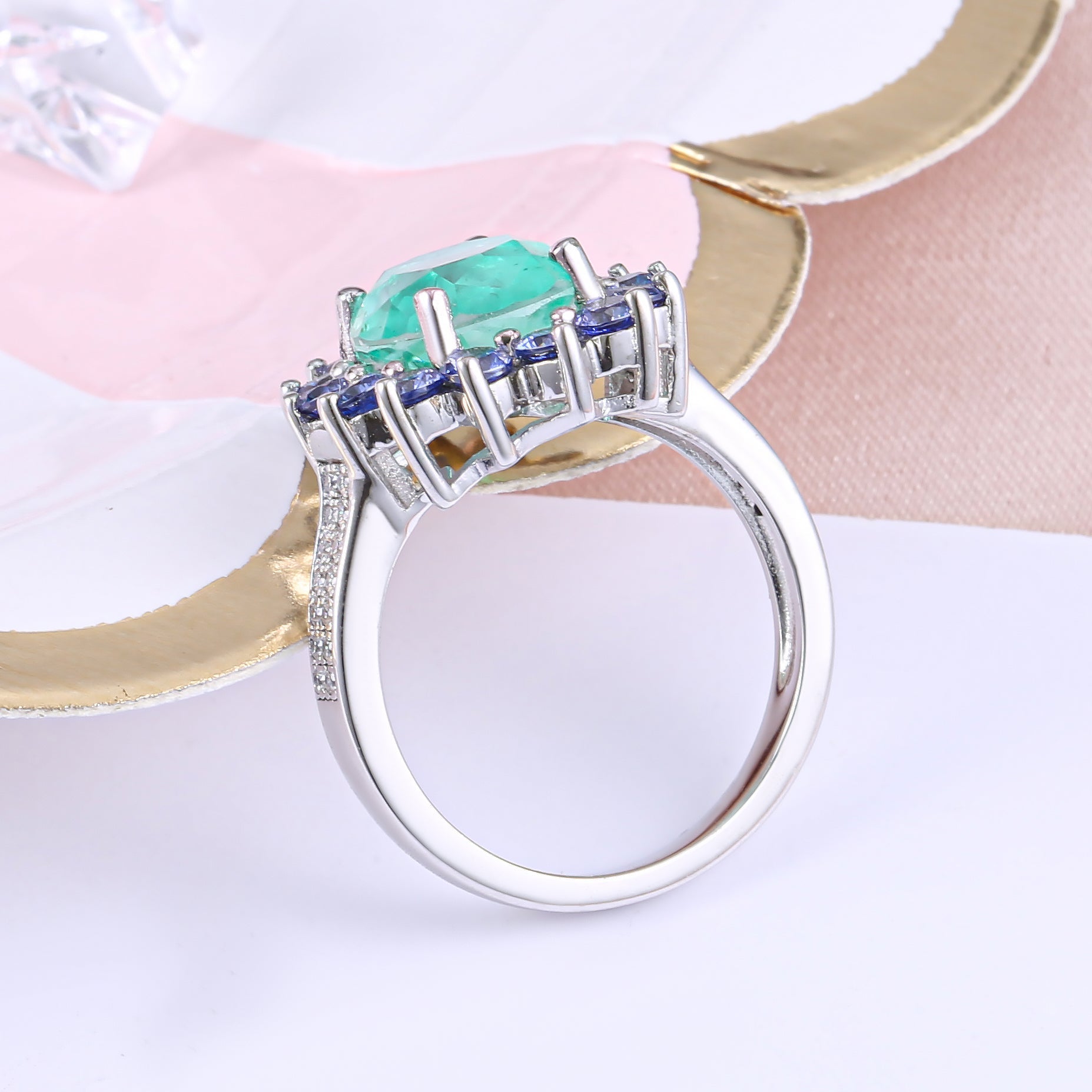 A beautiful Brazilian created blue tourmaline Paraiba halo ring set in 925 sterling silver with a white gold finish, showcasing a vibrant blue stone.