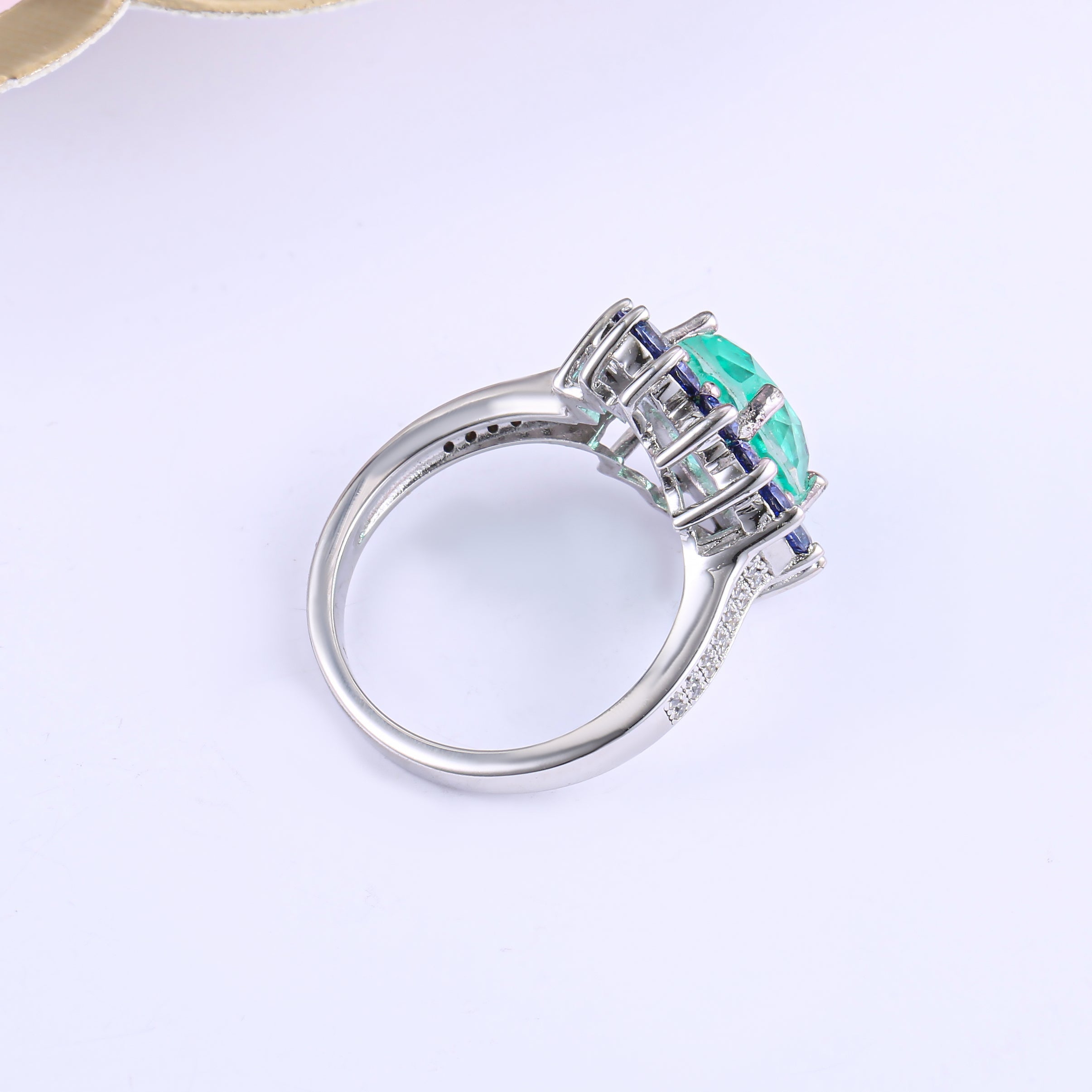 A beautiful Brazilian created blue tourmaline Paraiba halo ring set in 925 sterling silver with a white gold finish, showcasing a vibrant blue stone.