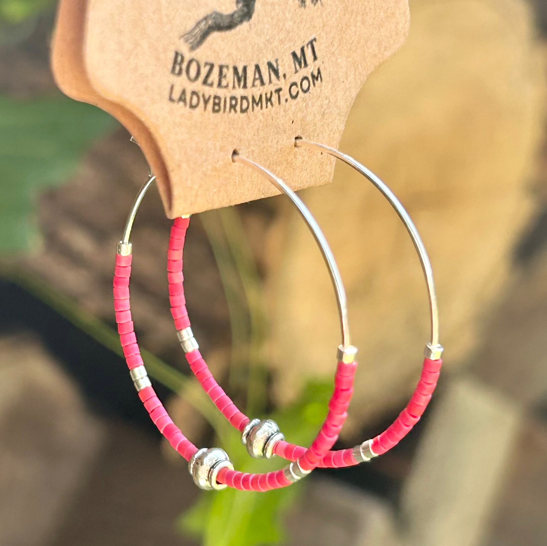 A pair of vibrant brick red and silver beaded hoop earrings featuring Miyuki Delica seed beads on a stainless steel hoop.