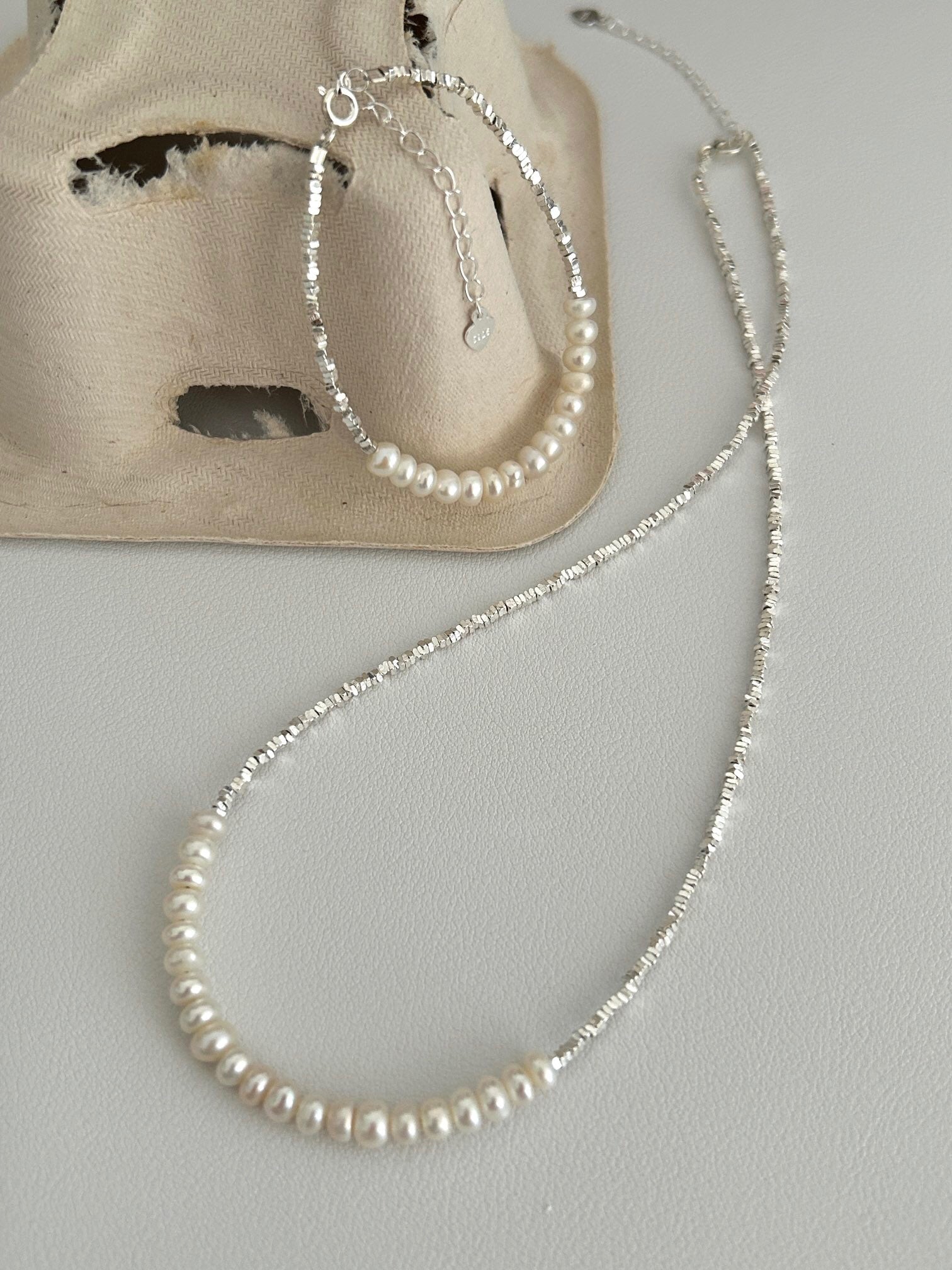 A beautiful Broken Silver Natural Pearl Bracelet and Necklace featuring natural pearls and gold vermeil on sterling silver, showcasing elegance and craftsmanship.