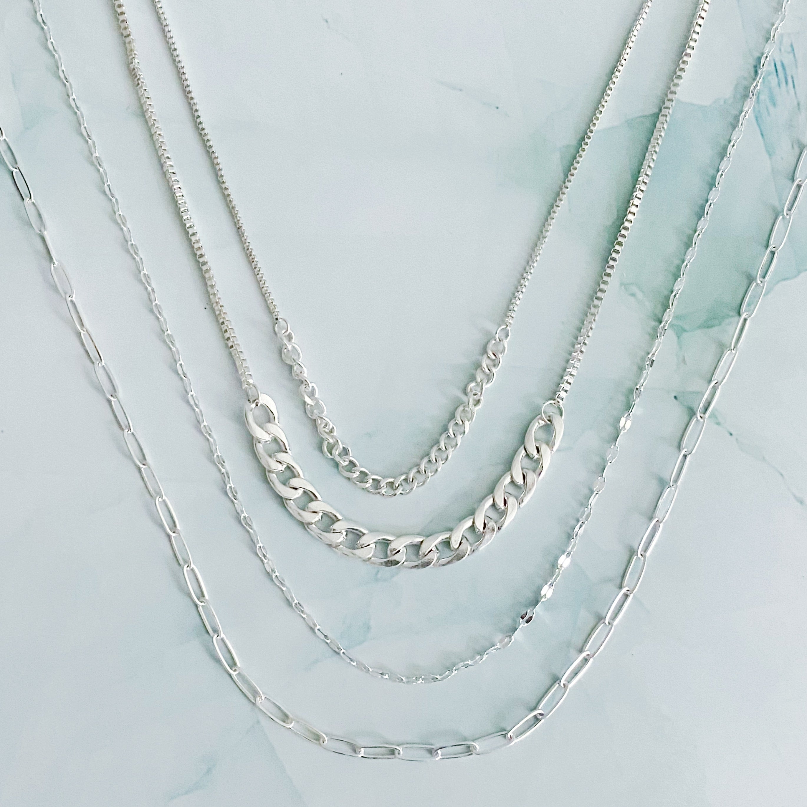 Brooklyn Four Chains Necklace Set of 3 featuring layered Cuban, link, and textured chains in alloy metal.