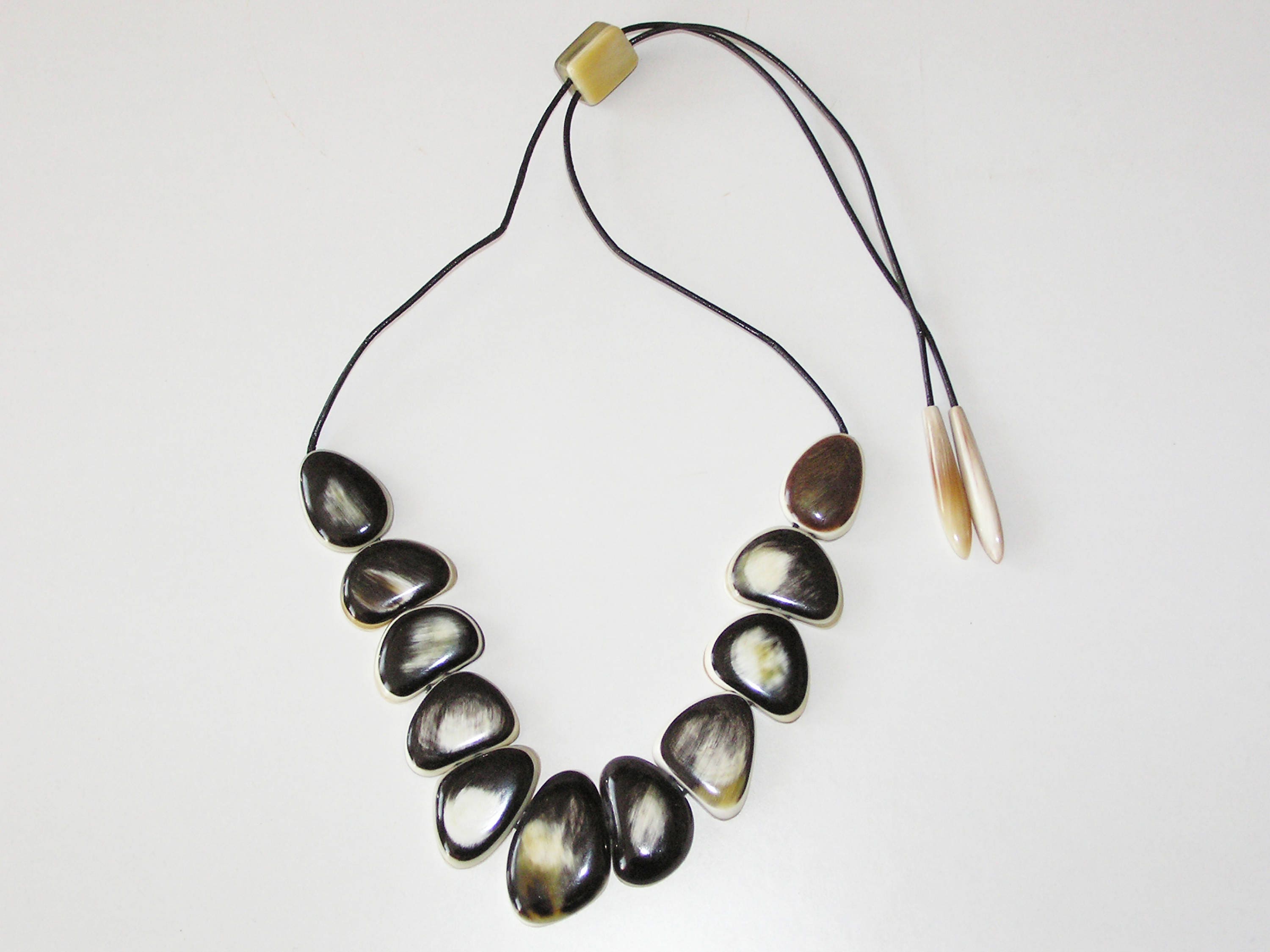 Handmade bull horn necklace featuring polished ovals and leather cord, showcasing natural beauty and elegance.