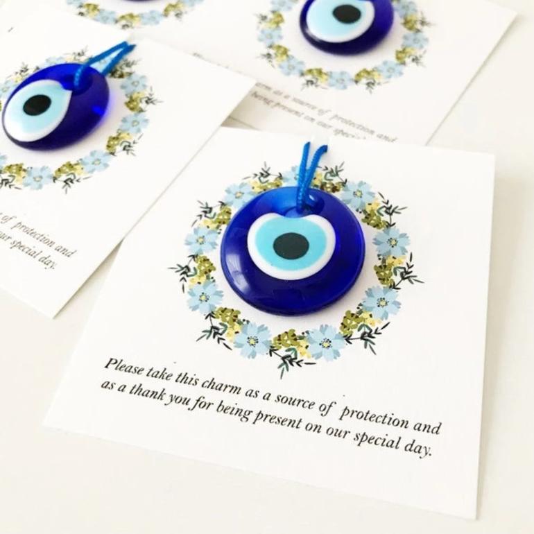 Bulk Greek wedding favors featuring handmade blue glass evil eye beads with personalized cards, symbolizing good luck and protection.