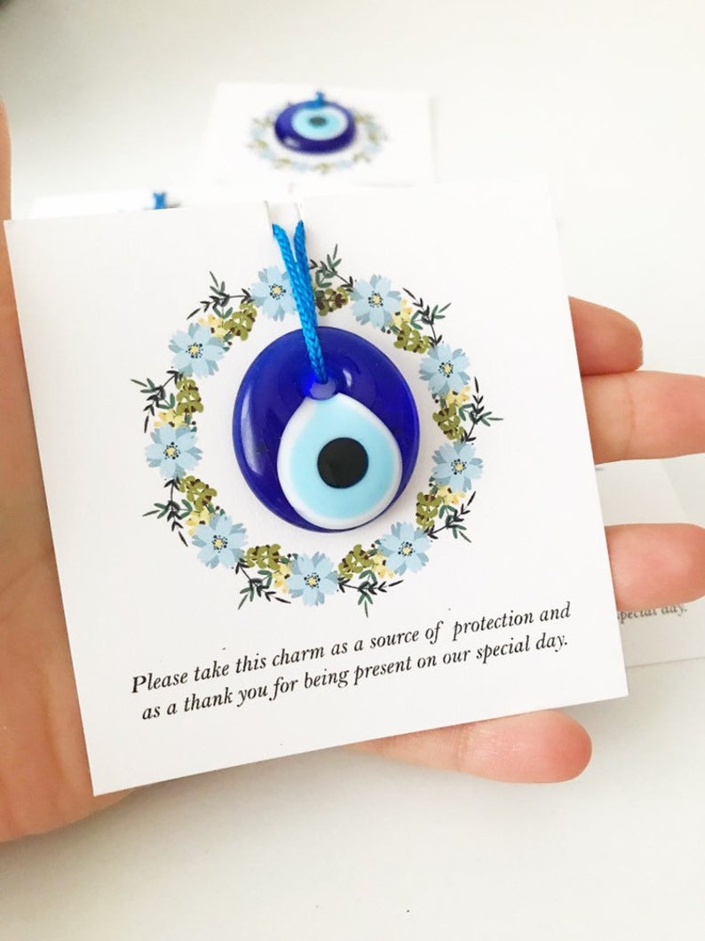 Bulk Greek wedding favors featuring handmade blue glass evil eye beads with personalized cards, symbolizing good luck and protection.