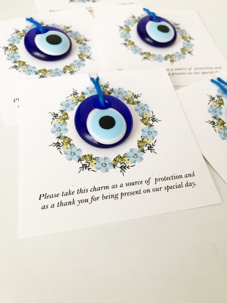 Bulk Greek wedding favors featuring handmade blue glass evil eye beads with personalized cards, symbolizing good luck and protection.