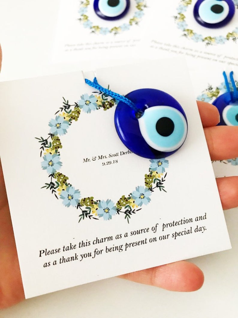 Bulk Greek wedding favors featuring handmade blue glass evil eye beads with personalized cards, symbolizing good luck and protection.