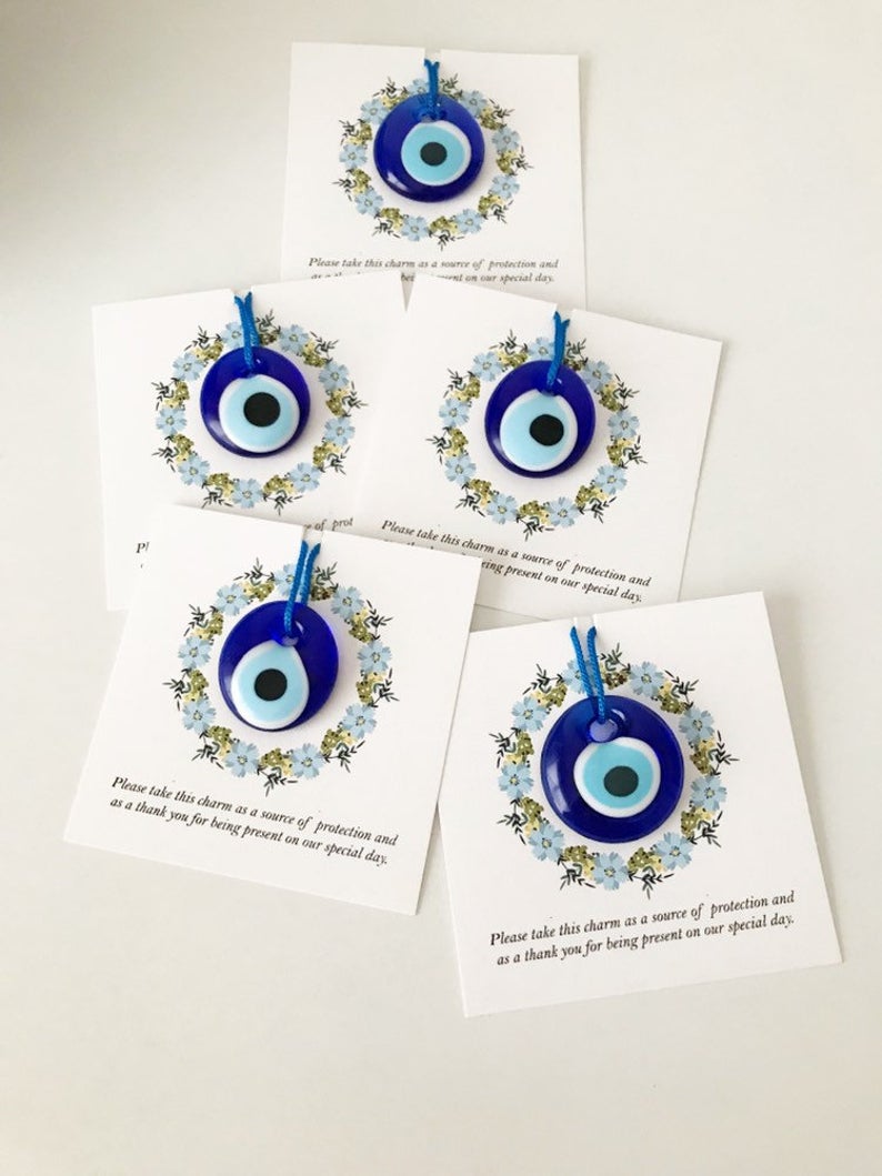 Bulk Greek wedding favors featuring handmade blue glass evil eye beads with personalized cards, symbolizing good luck and protection.