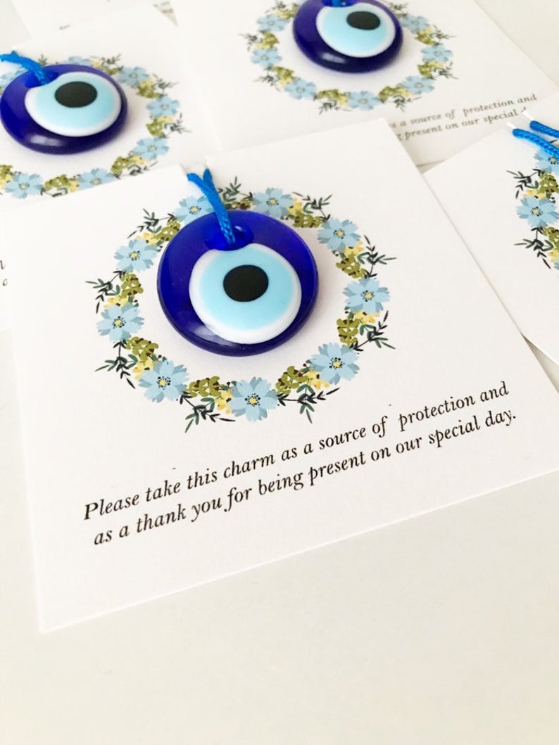 Bulk Greek wedding favors featuring handmade blue glass evil eye beads with personalized cards, symbolizing good luck and protection.