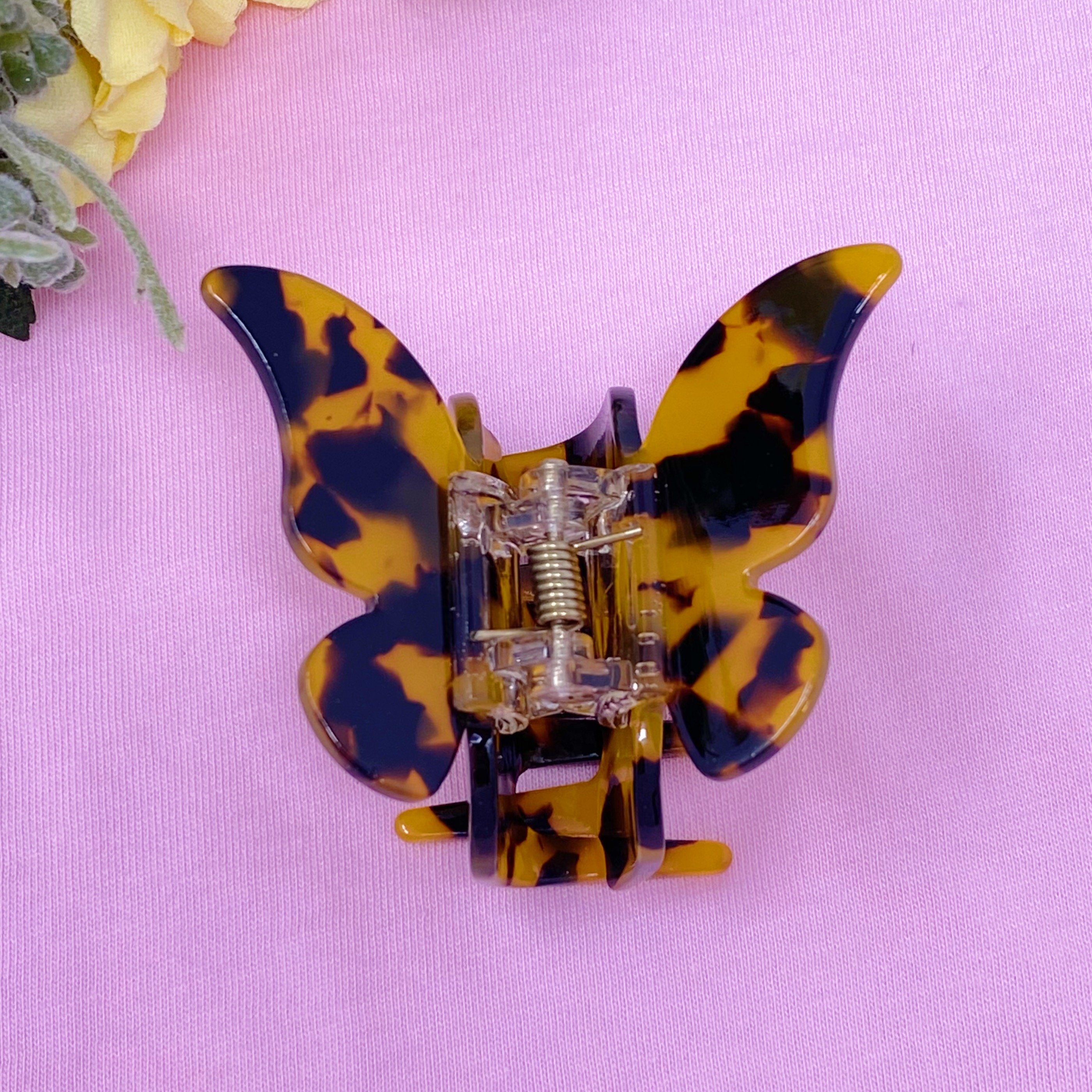 A stylish butterfly-shaped acrylic hair claw in elegant design, perfect for securing hair in various styles.