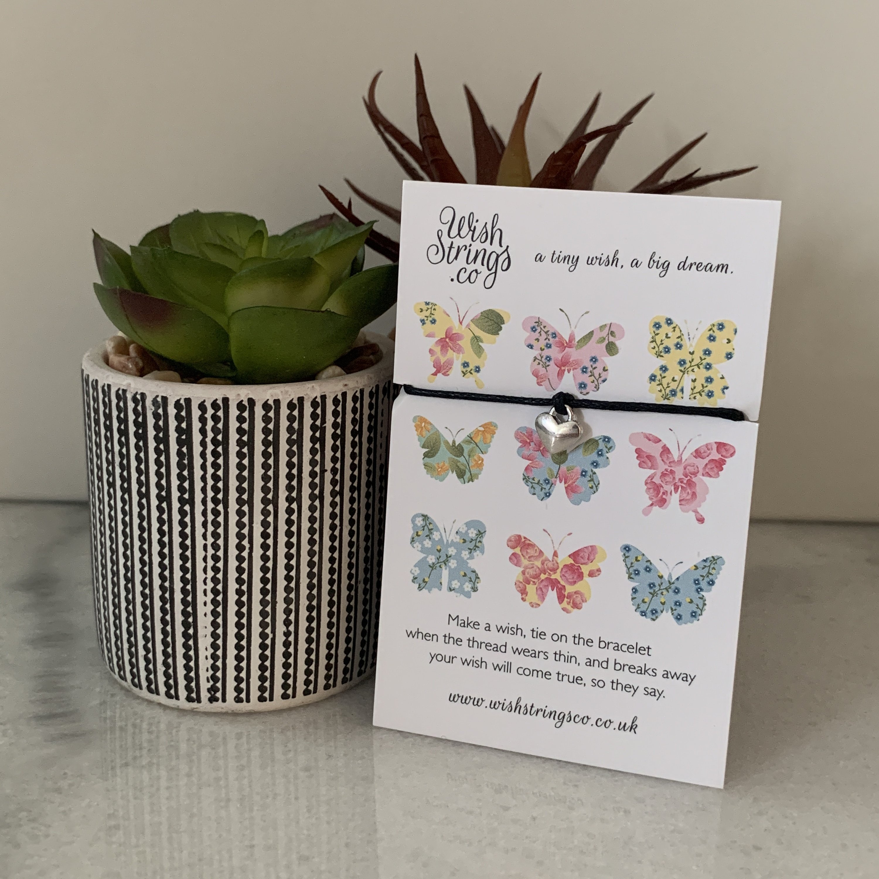 Butterfly Heart Wish Bracelet with Tibetan Silver charm on waxed cotton cord, beautifully presented on a luxury display card.