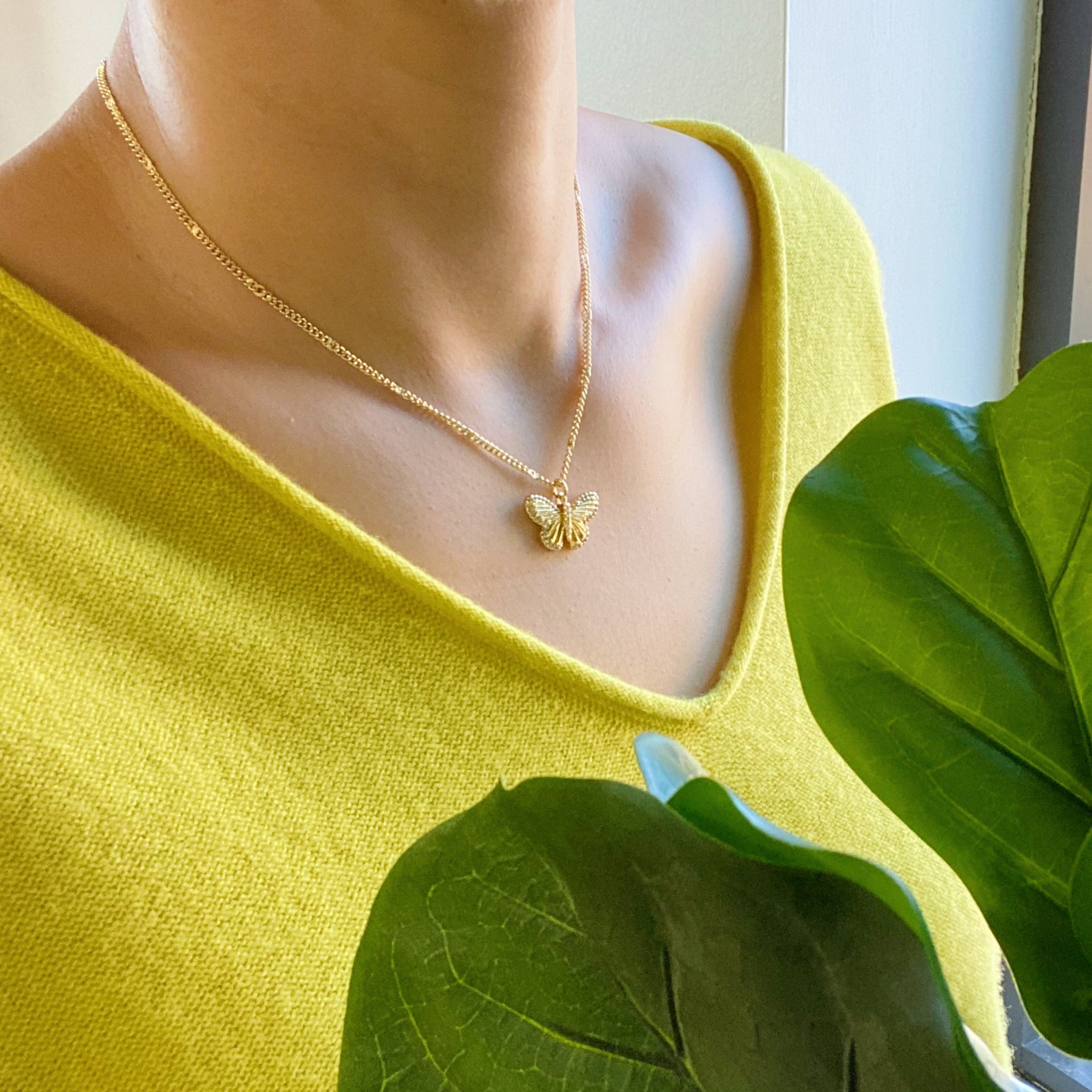 A delicate Butterfly In Flight Necklace featuring a detailed butterfly charm embellished with cubic zirconia stones on a gold plated brass chain.