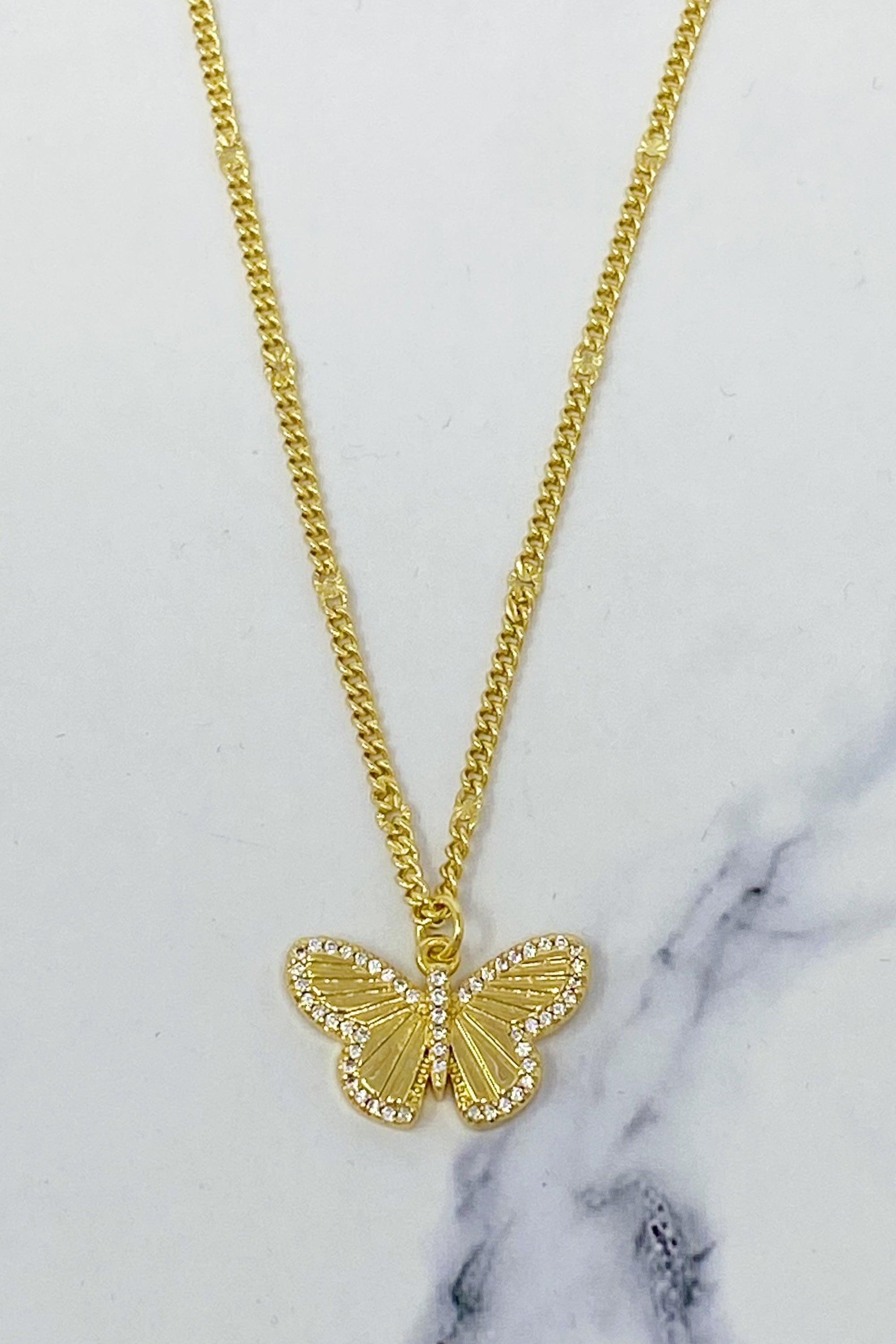 A delicate Butterfly In Flight Necklace featuring a detailed butterfly charm embellished with cubic zirconia stones on a gold plated brass chain.