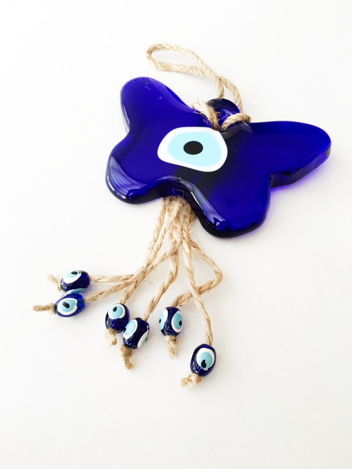 A beautifully crafted Butterfly Macrame Evil Eye Wall Hanging featuring a glass evil eye charm, showcasing intricate macrame design.