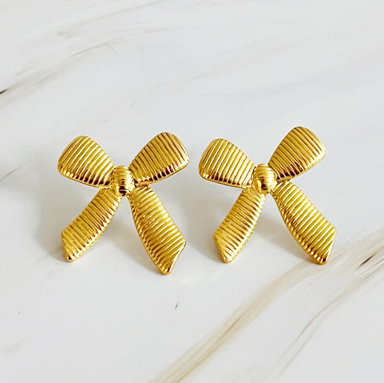 Elegant Cabled Bow Stud Earrings in 18k gold plated stainless steel, showcasing a unique cabling design.