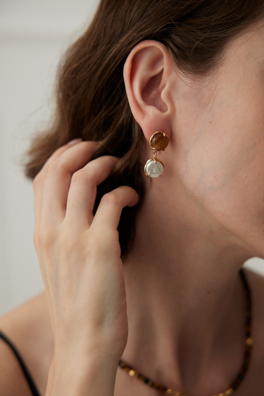 Café Au Lait Mini Pearl Ball Earring featuring vintage gold, coffee-colored resin, and delicate pearls, showcasing adjustable design for comfort.