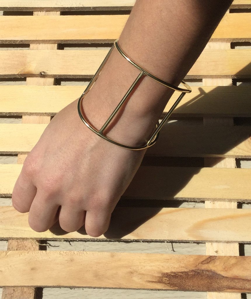 A stylish Cage Cuff Bracelet in gold and silver, showcasing its minimalist design and adjustable fit.