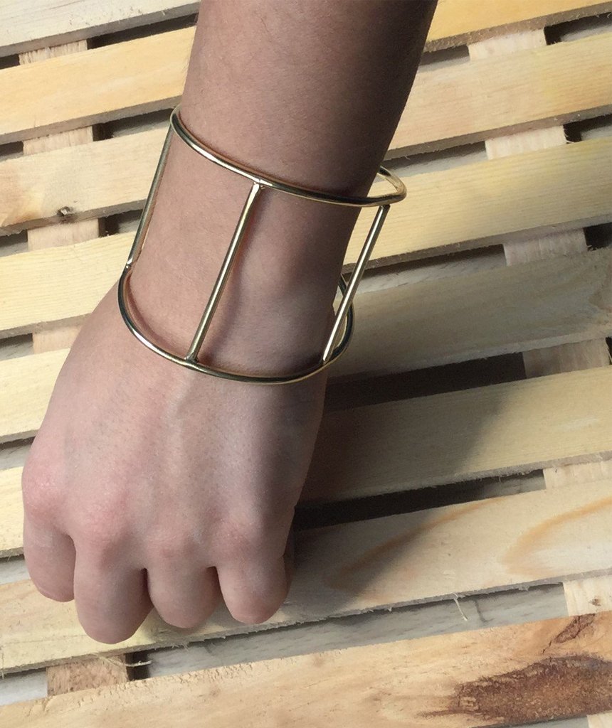 A stylish Cage Cuff Bracelet in gold and silver, showcasing its minimalist design and adjustable fit.