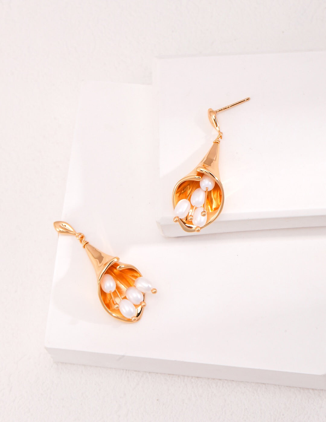 Elegant Calla Lily Pearl Earrings featuring natural pearls and sterling silver, showcasing a unique floral design.