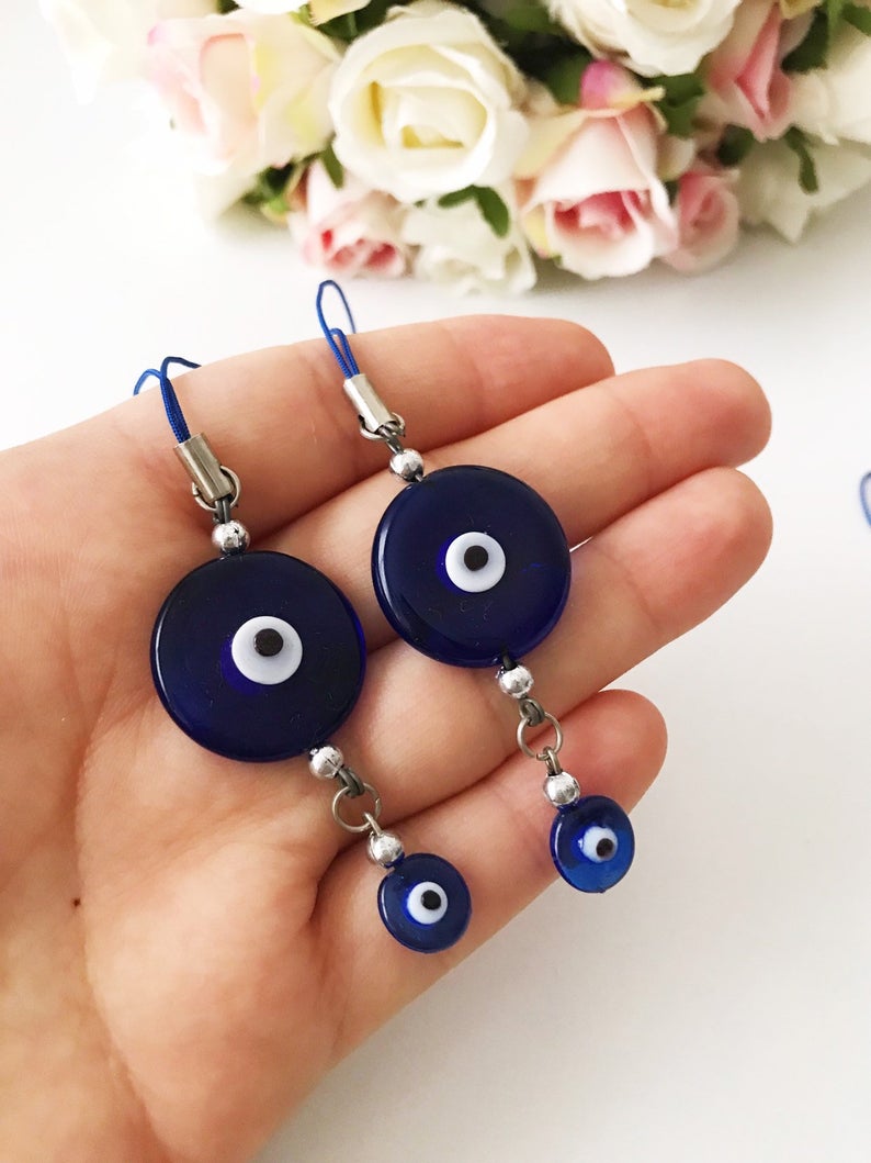 Handmade car rear view mirror charm featuring blue glass evil eye beads, symbolizing protection and good luck.