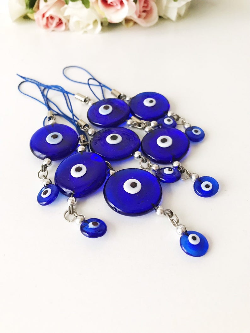 Handmade car rear view mirror charm featuring blue glass evil eye beads, symbolizing protection and good luck.