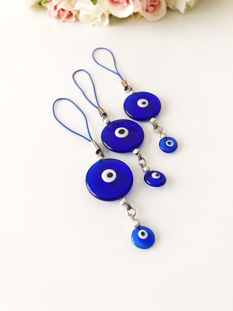 Handmade car rear view mirror charm featuring blue glass evil eye beads, symbolizing protection and good luck.