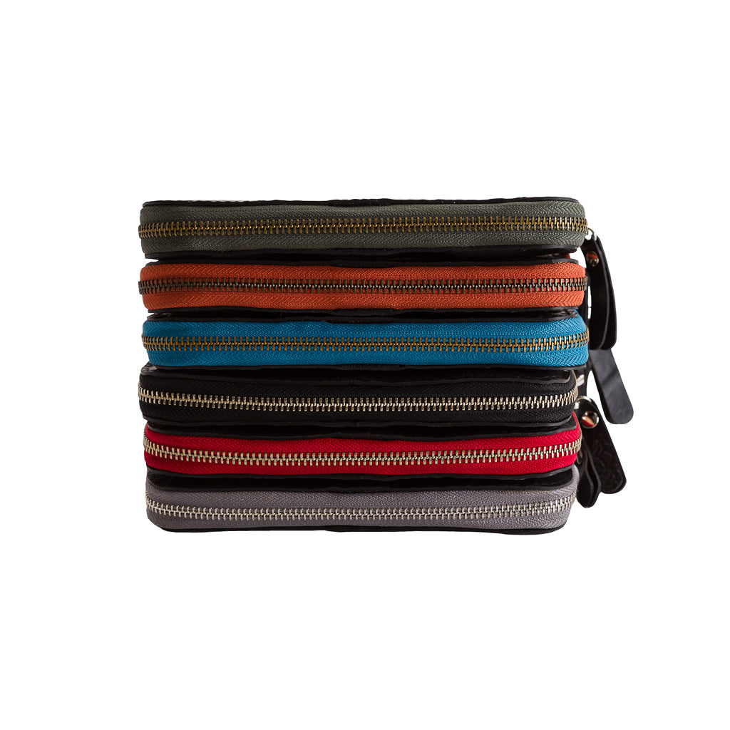 Caroline Long Zip Vegan Purse in six vibrant colours, showcasing unique patterns from recycled rubber with colorful stitching.