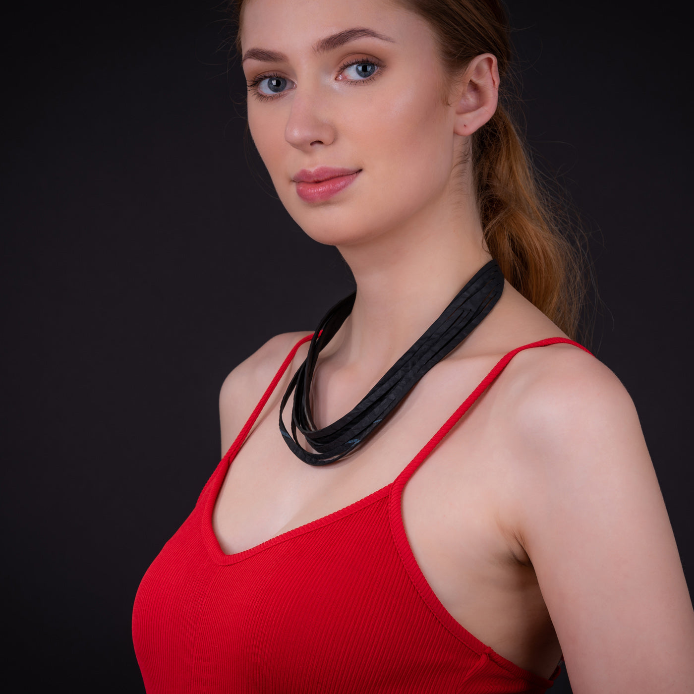 Carter Layered Recycled Rubber Necklace showcasing its unique multi-strap design and texture from recycled tyre inner tubes.