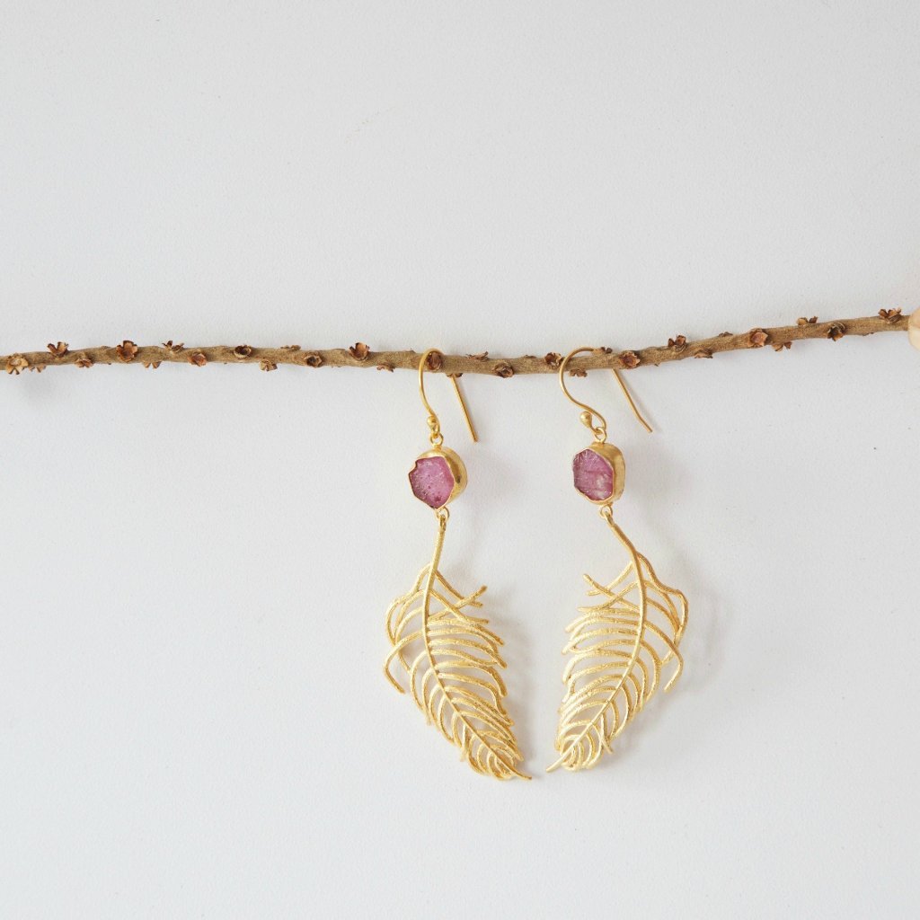 Elegant Cast Feather Earrings with 18K gold plating and clear quartz, showcasing a fluid feather design.