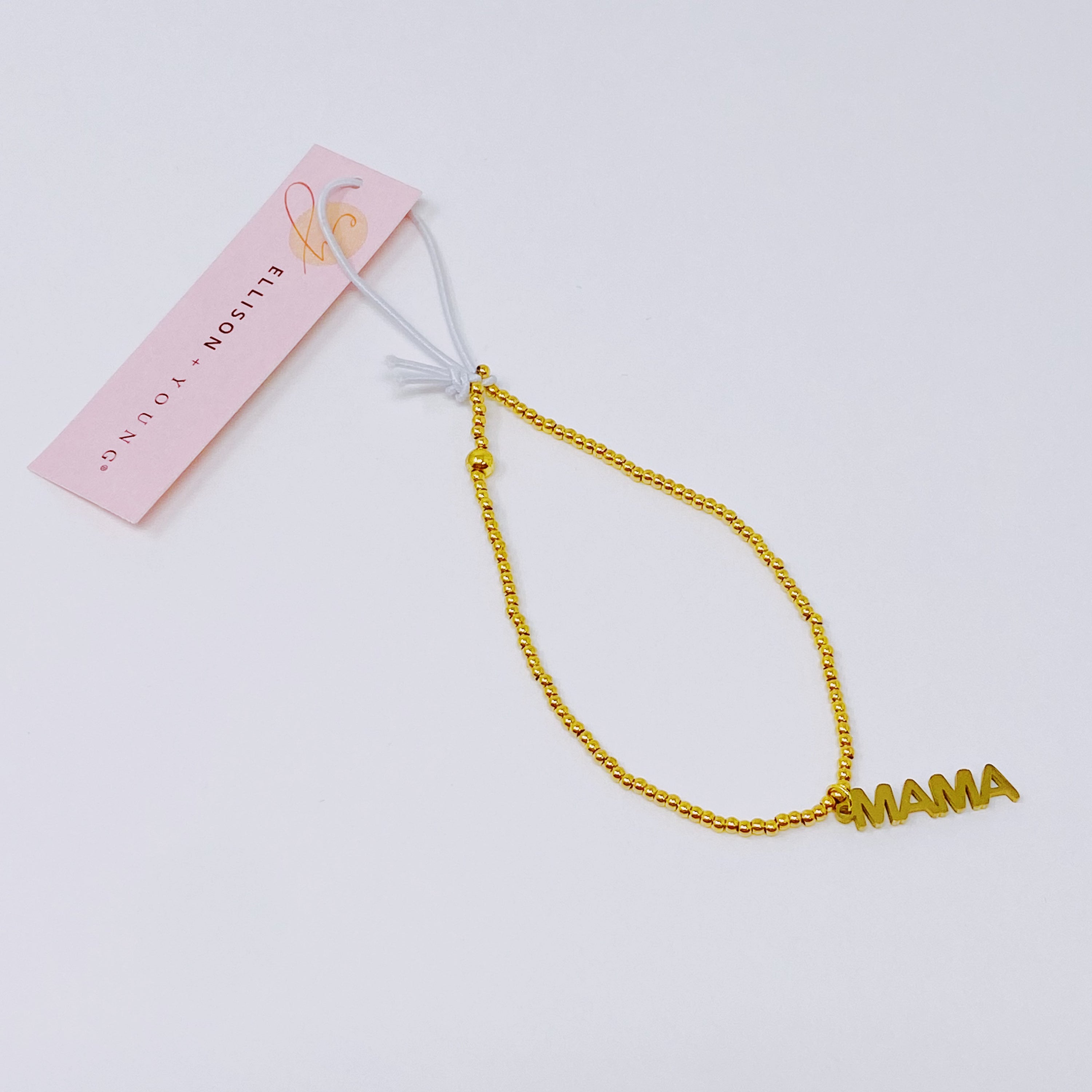 Charming Mama Stretch Bracelet featuring golden ball beads and a MAMA cutout charm, elegantly displayed on a soft background.