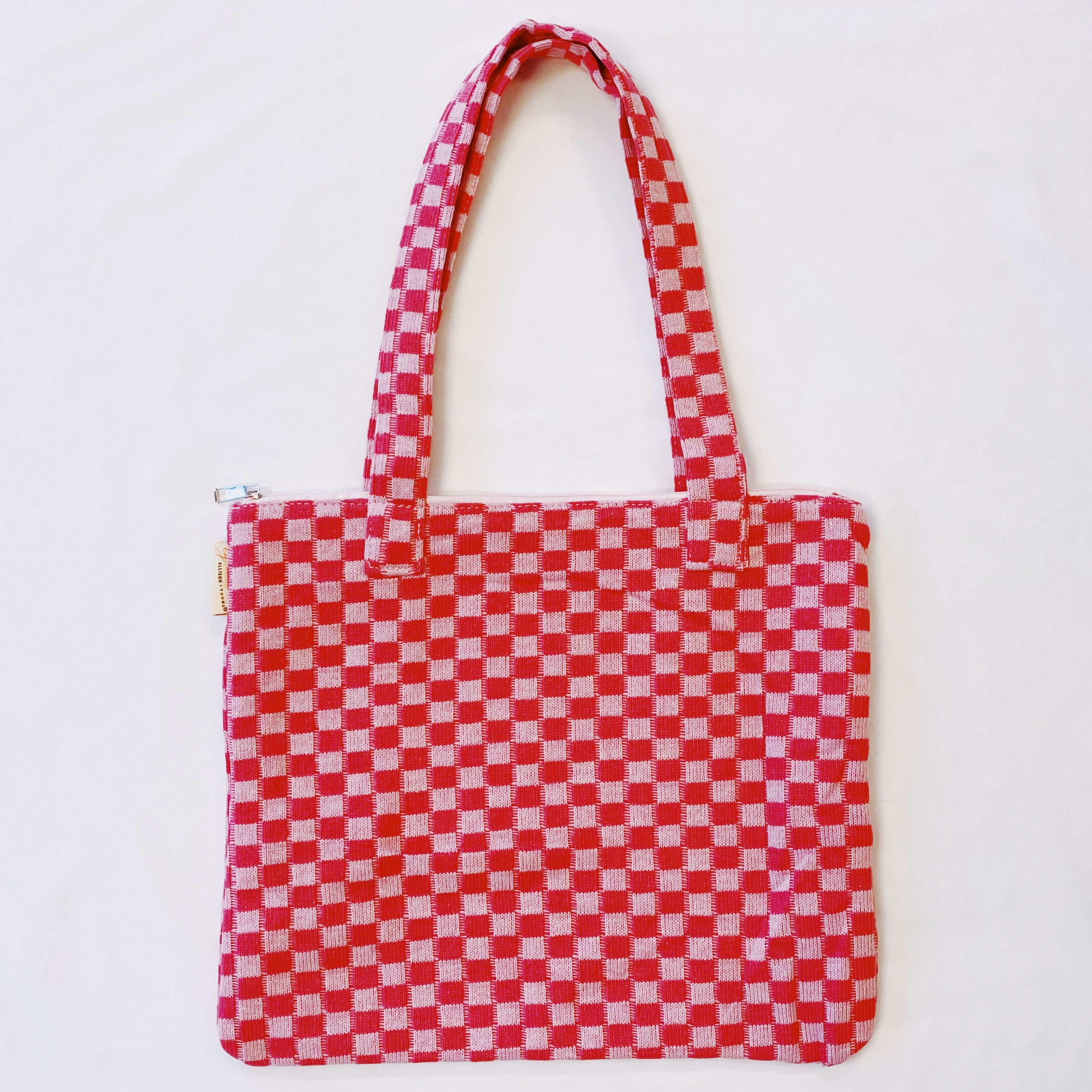 Check Yourself Zipped Tote Bag featuring a classic checkered pattern, secure zipper closure, and durable fabric straps.