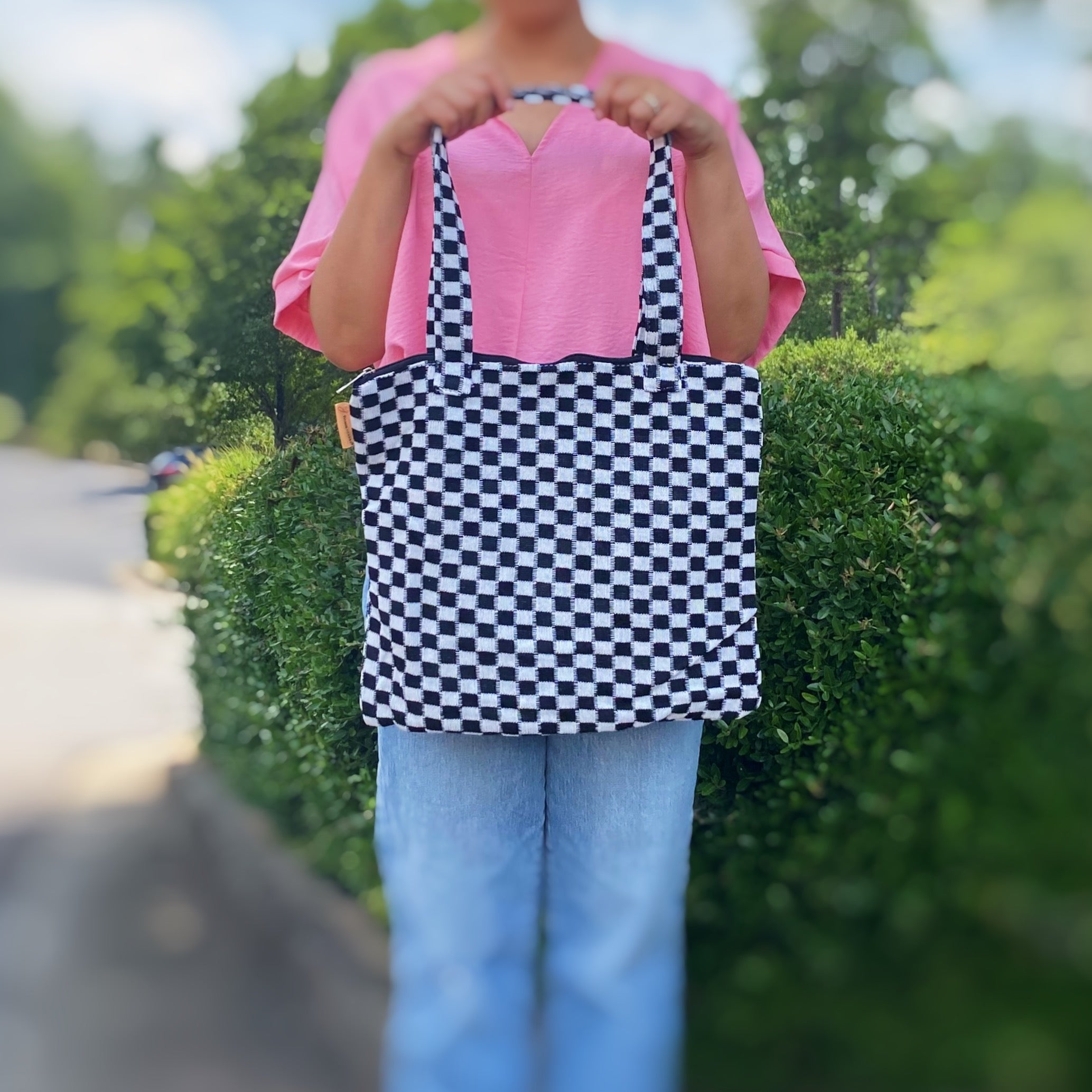 Check Yourself Zipped Tote Bag featuring a classic checkered pattern, secure zipper closure, and durable fabric straps.