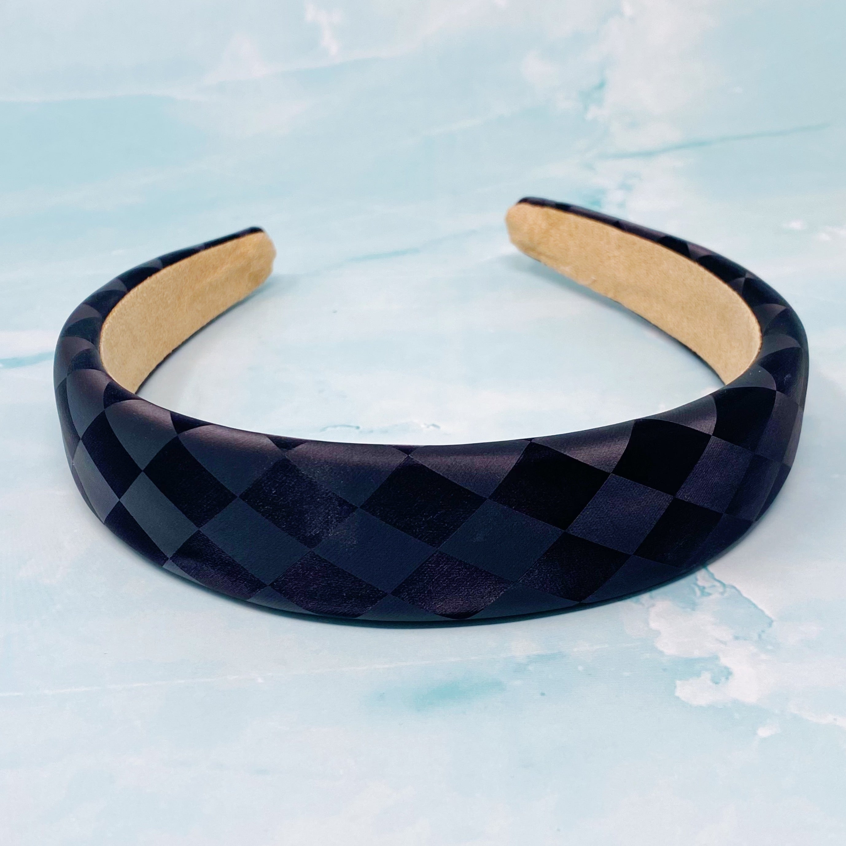 Checked In Mute Headband featuring a stylish checkered diamond pattern in muted tones, designed for comfort and all-day wear.