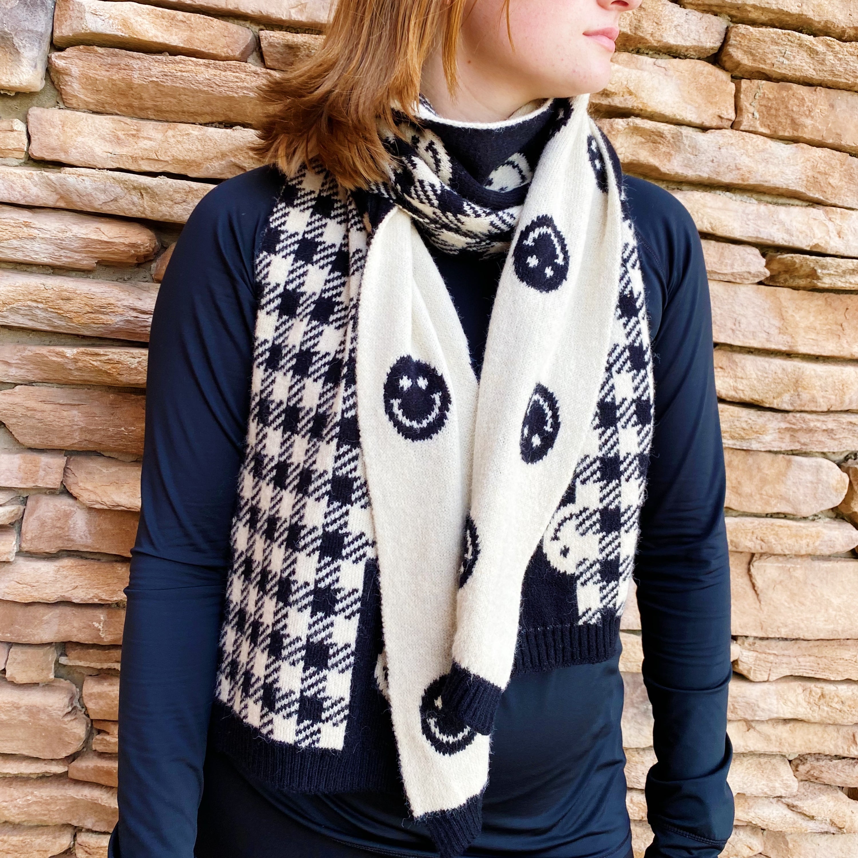 Checked On Happiness Cozy Scarf featuring a happy face and checkered pattern, reversible design, and soft knit fabric.