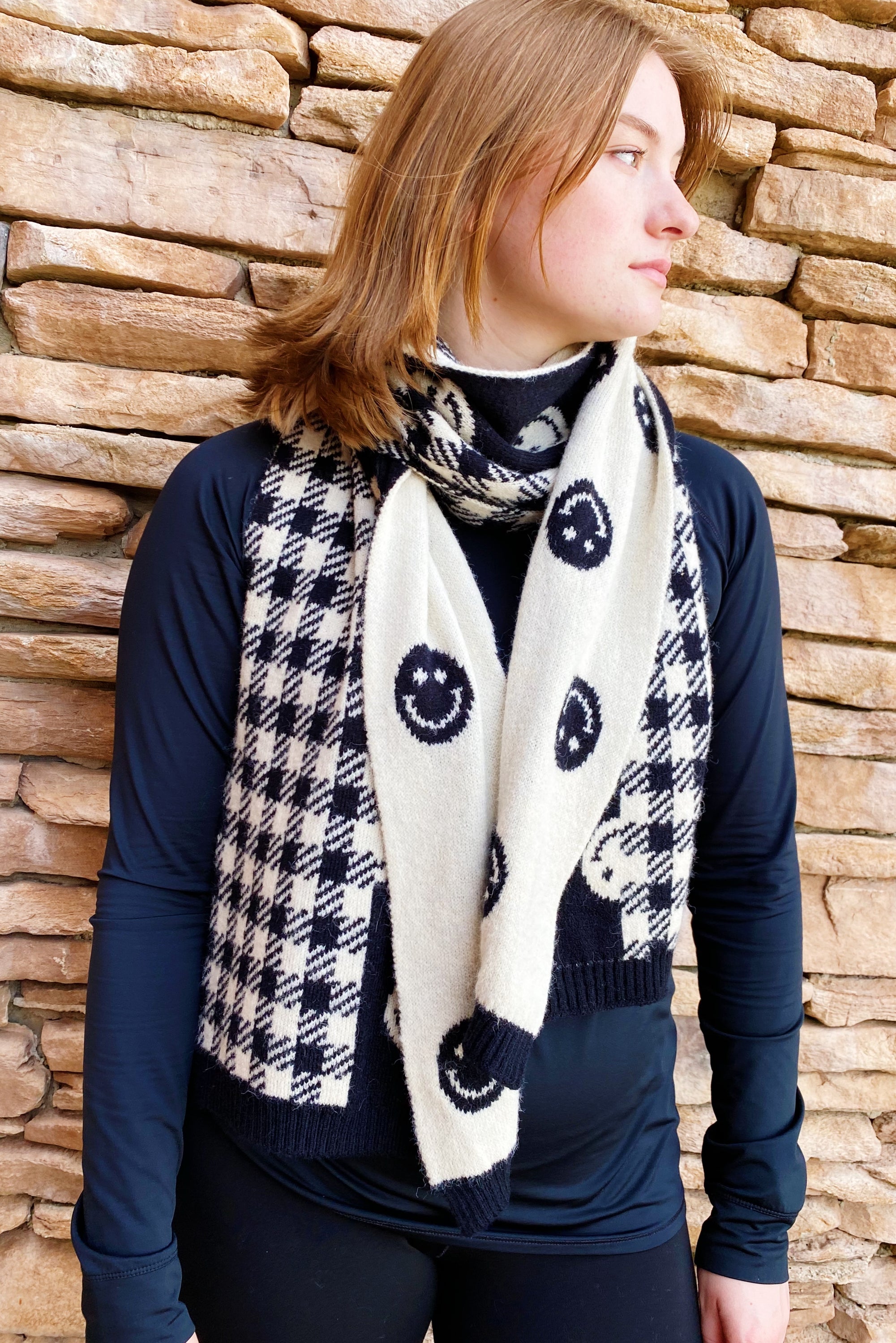 Checked On Happiness Cozy Scarf featuring a happy face and checkered pattern, reversible design, and soft knit fabric.