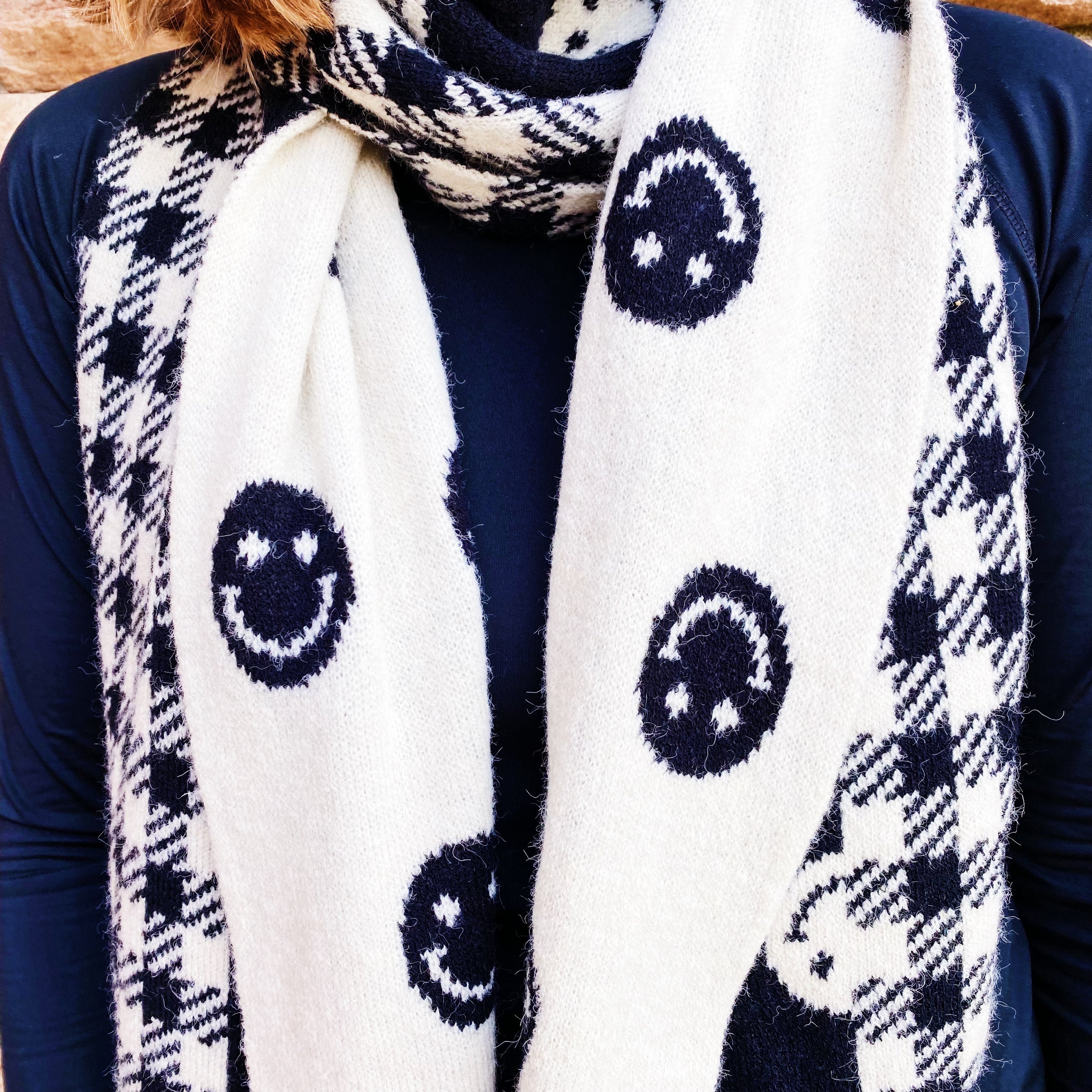 Checked On Happiness Cozy Scarf featuring a happy face and checkered pattern, reversible design, and soft knit fabric.