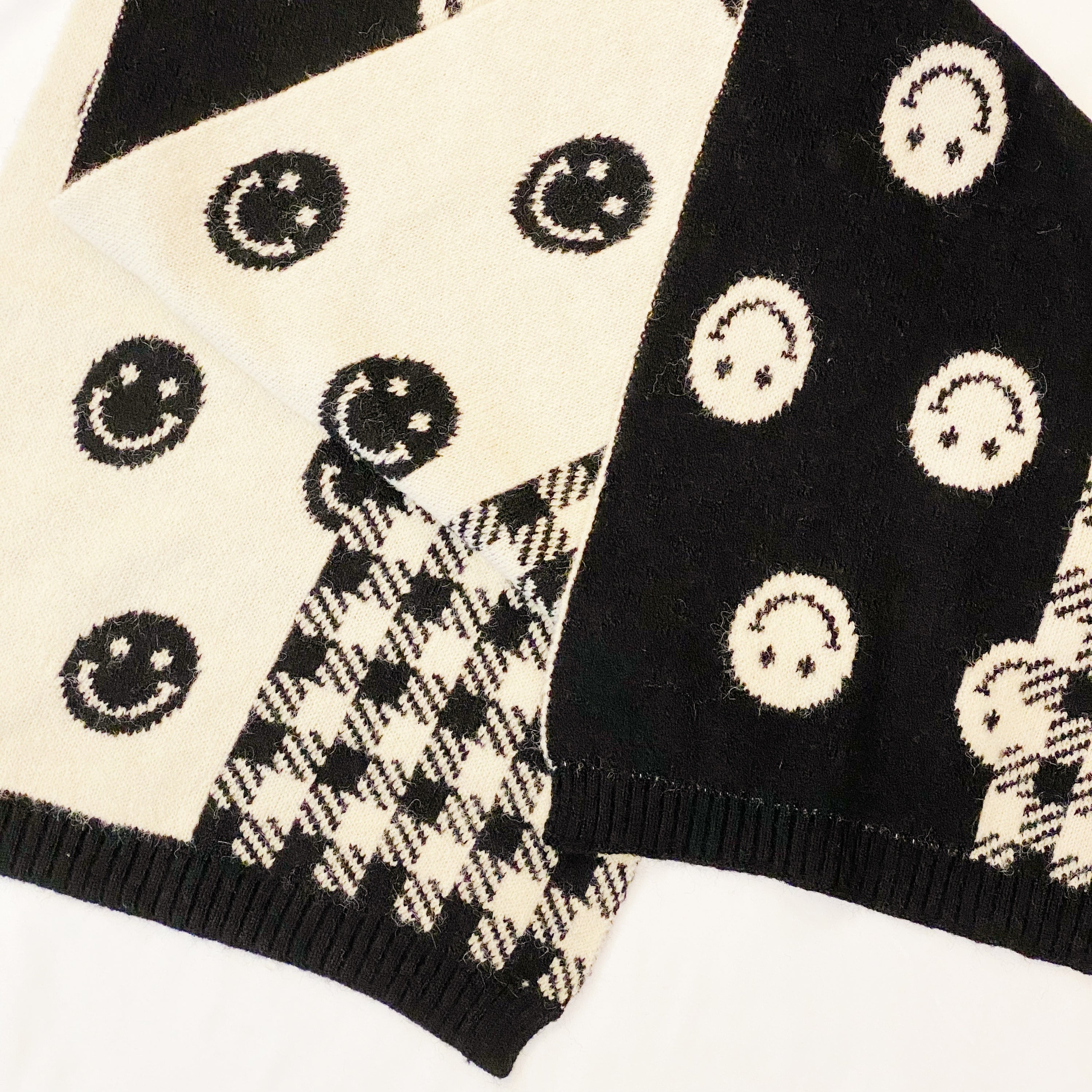 Checked On Happiness Cozy Scarf featuring a happy face and checkered pattern, reversible design, and soft knit fabric.