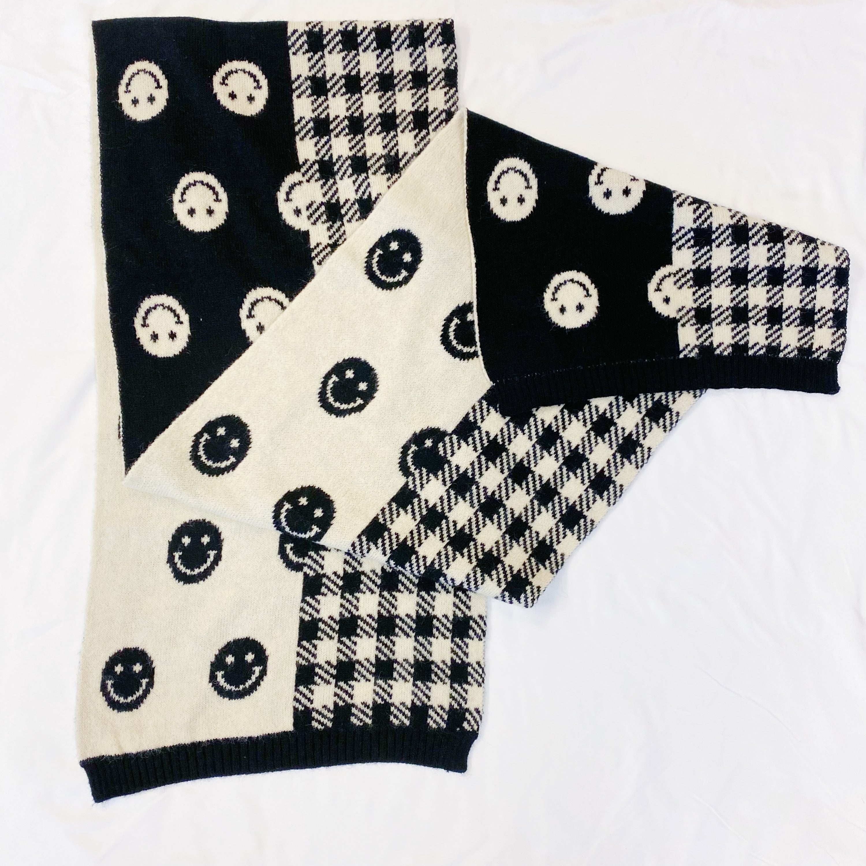 Checked On Happiness Cozy Scarf featuring a happy face and checkered pattern, reversible design, and soft knit fabric.