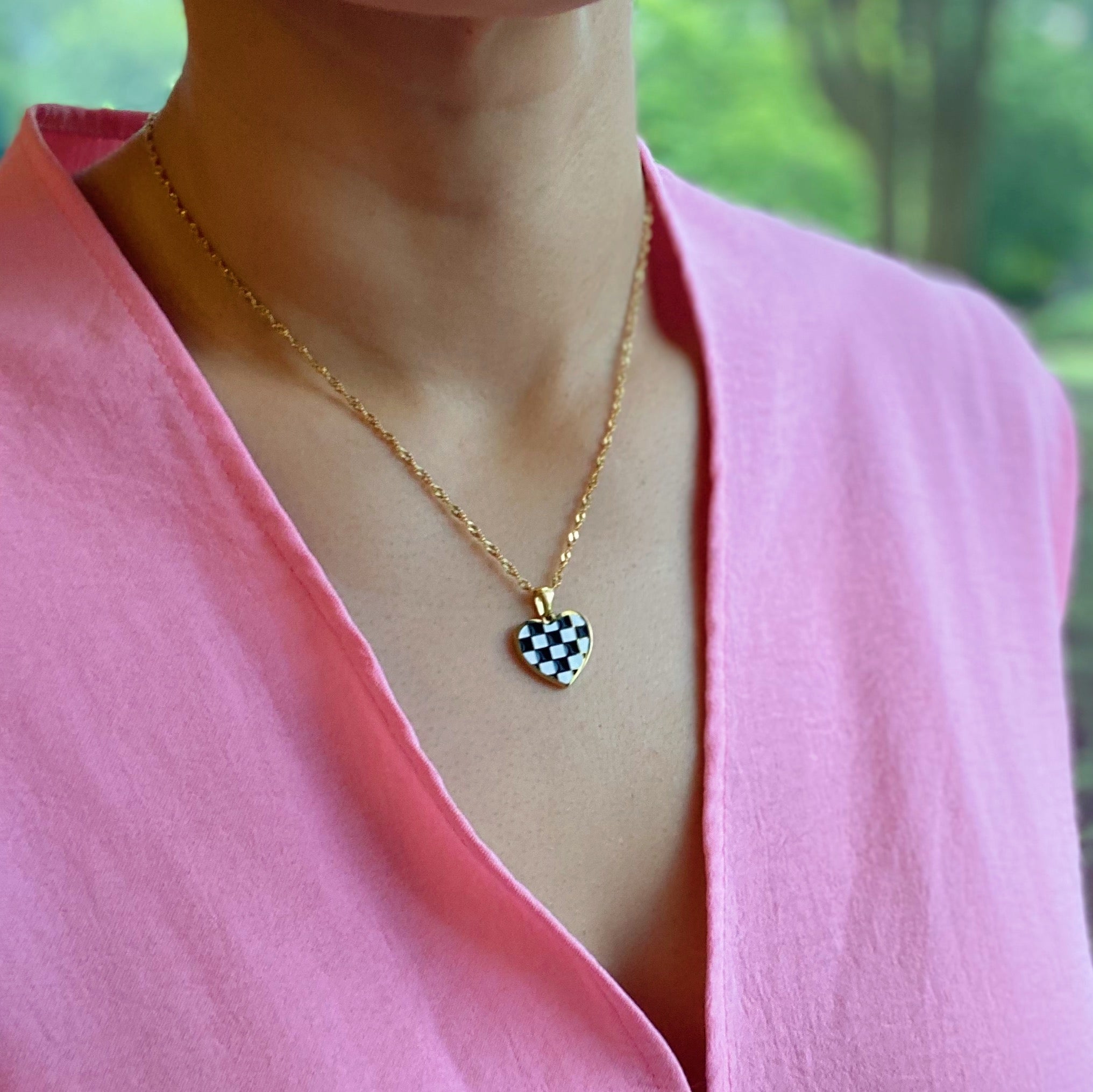 Checkered Heart Necklace featuring a unique heart pendant with a checkerboard pattern and a polished back, set on a gold plated chain.