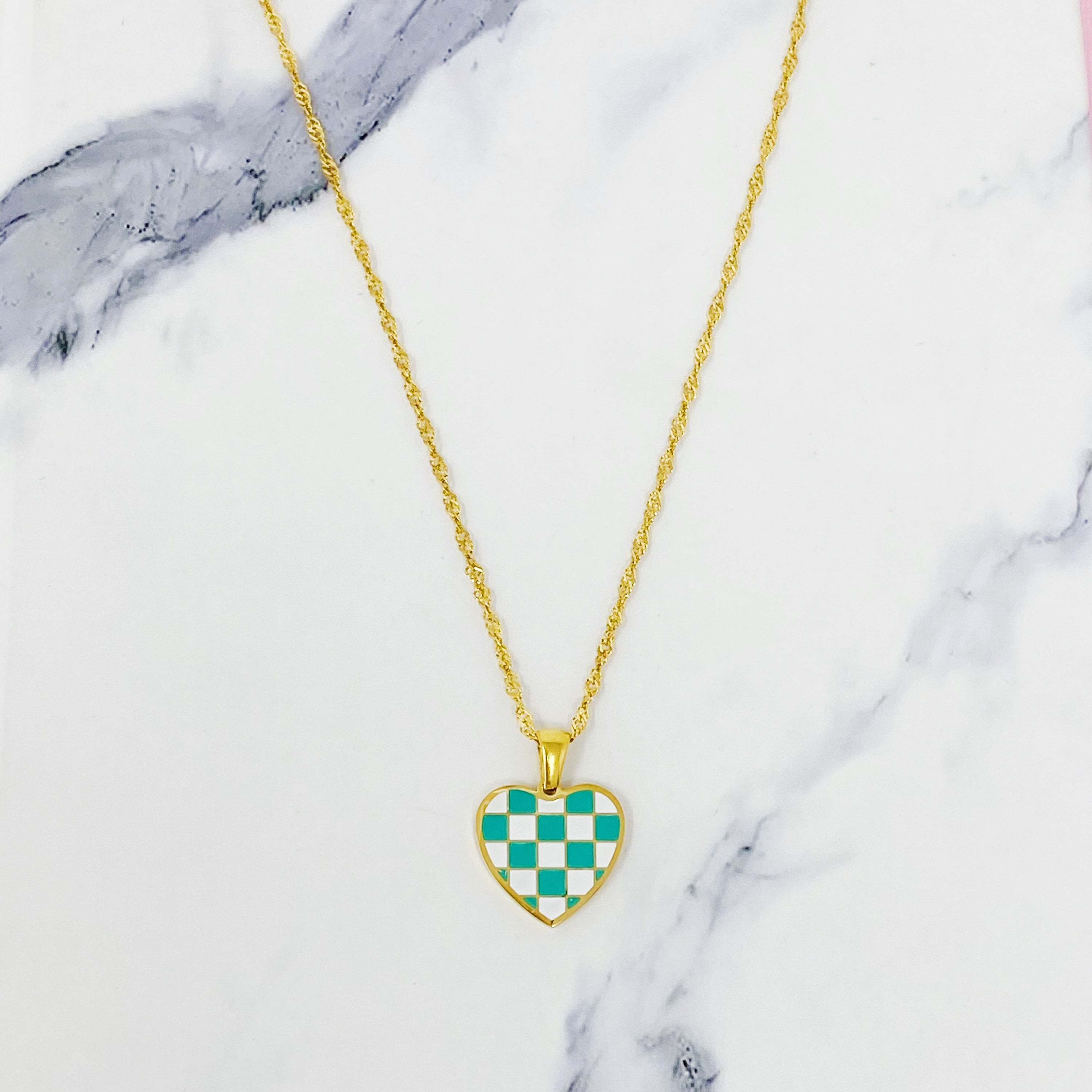 Checkered Heart Necklace featuring a unique heart pendant with a checkerboard pattern and a polished back, set on a gold plated chain.