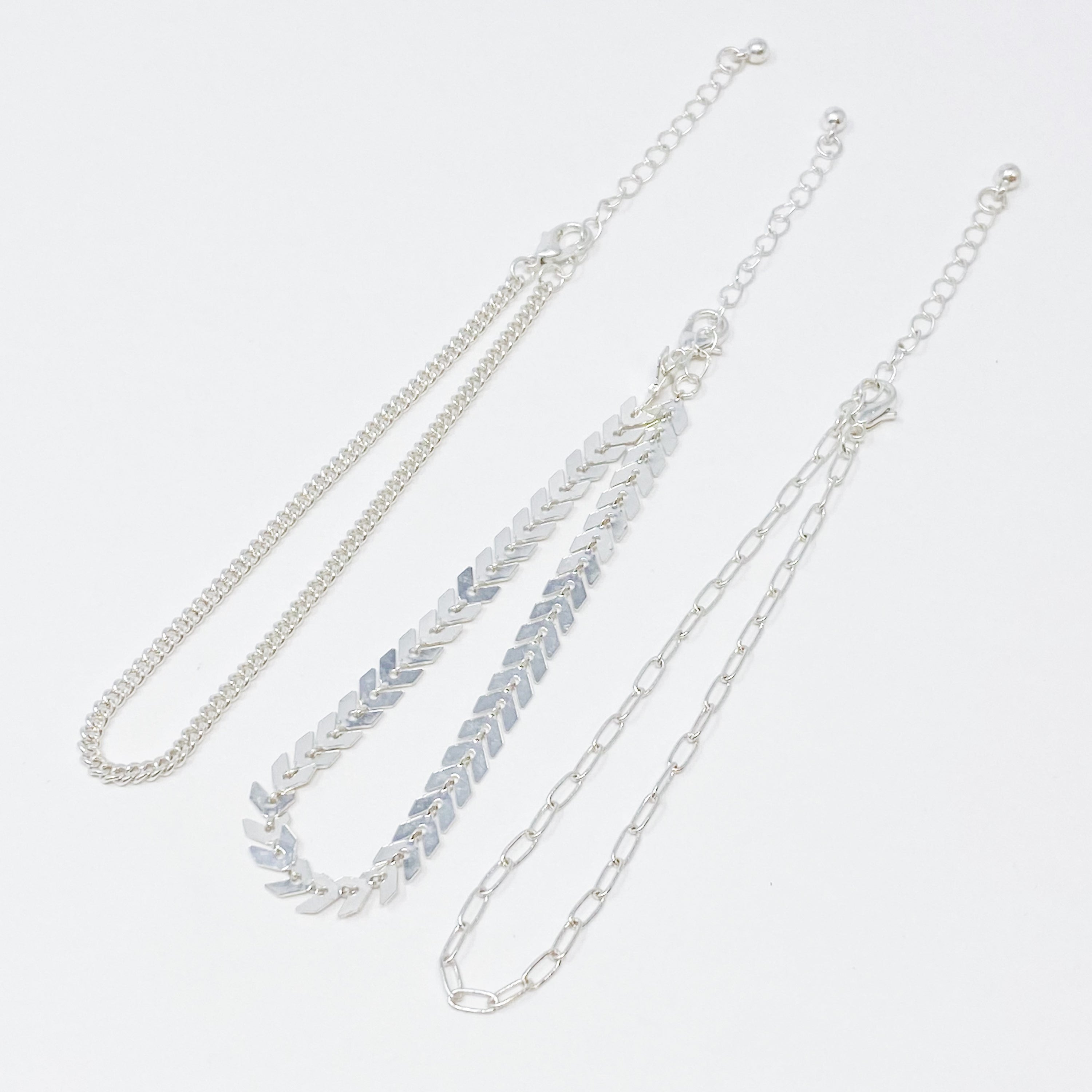 Set of 3 Chevron Chain Anklets in gold and silver plating, showcasing trendy layered design.