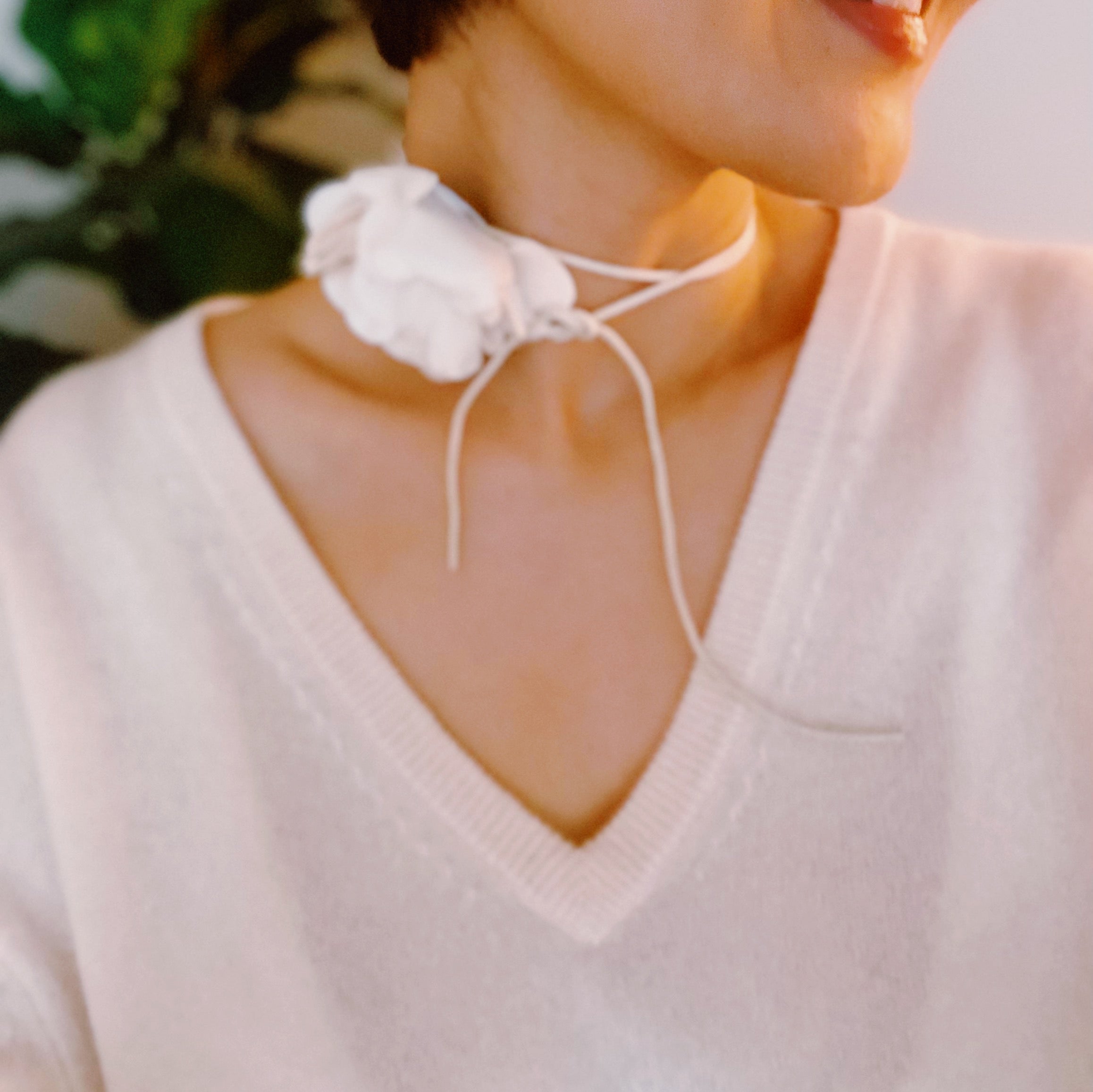 Chiffon Petals Rosette Tie necklace featuring a delicate fabric flower and a long slim strap, showcasing its versatility and lightweight design.