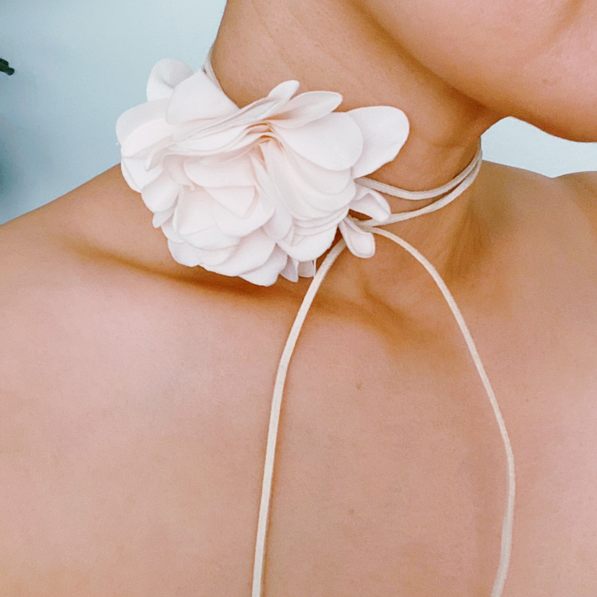 Chiffon Petals Rosette Tie necklace featuring a delicate fabric flower and a long slim strap, showcasing its versatility and lightweight design.