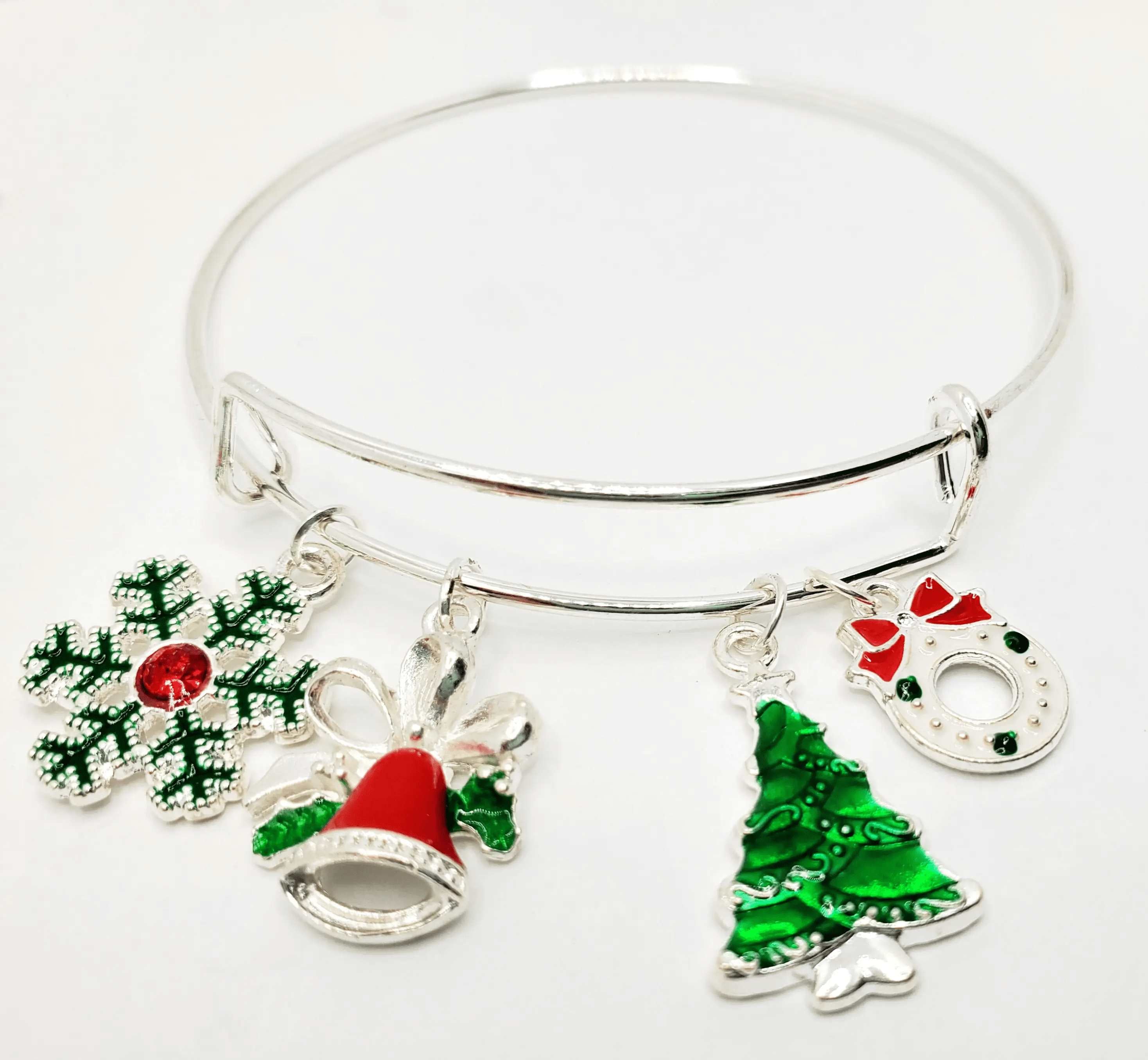 A beautiful silver Christmas charm bracelet featuring festive charms including a snowflake, bell, Christmas tree, and wreath.