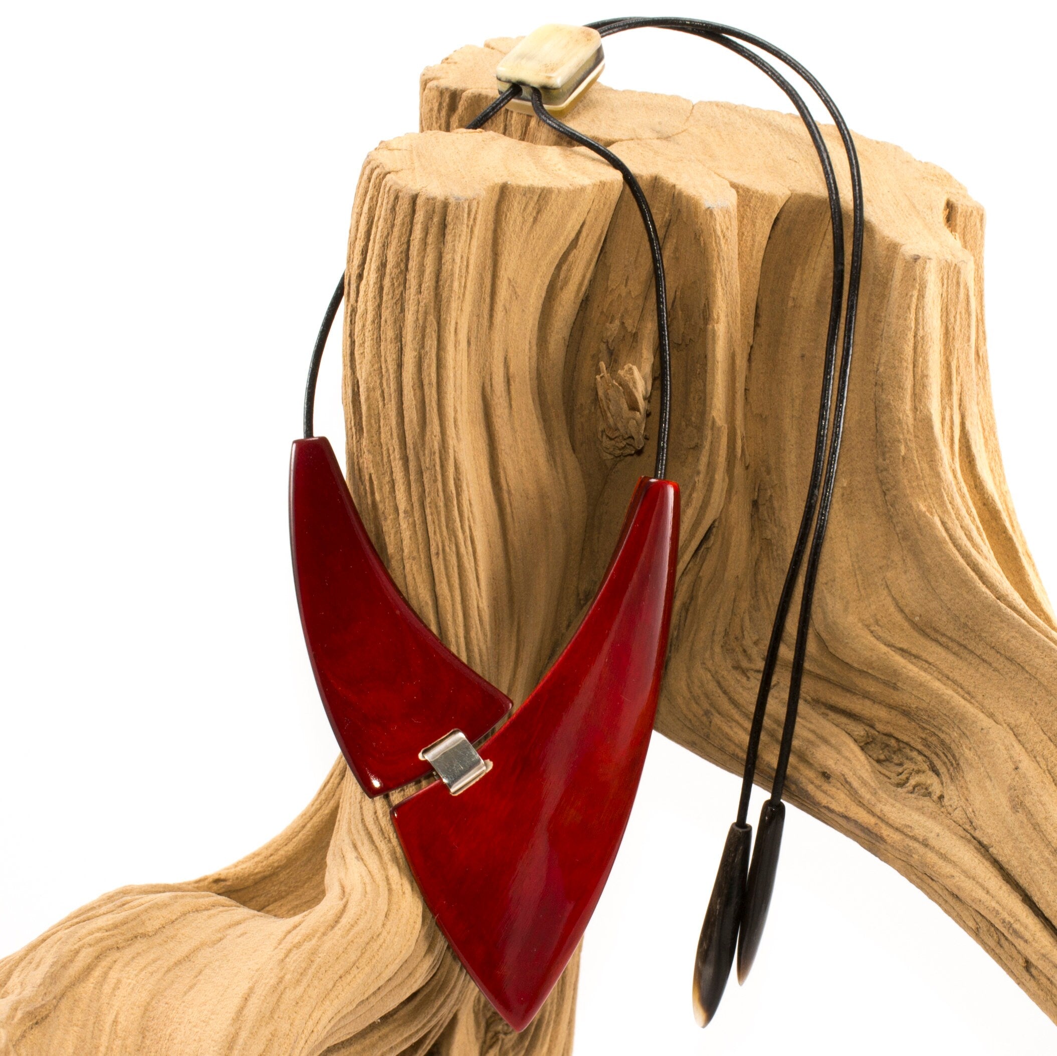 A chunky red necklace made from natural buffalo horns, featuring teardrop horn endings and an adjustable clasp, showcasing its unique design and craftsmanship.