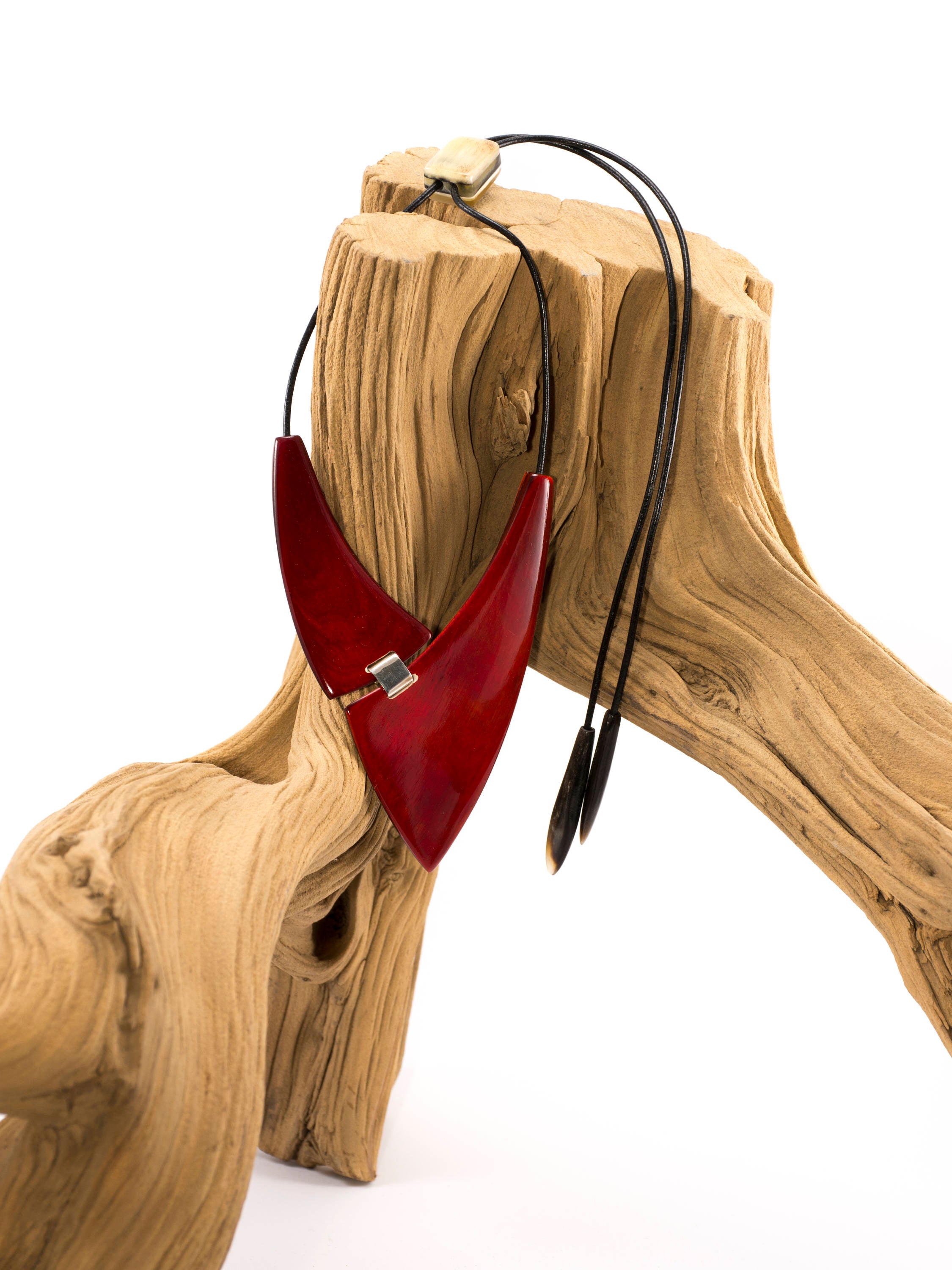 A chunky red necklace made from natural buffalo horns, featuring teardrop horn endings and an adjustable clasp, showcasing its unique design and craftsmanship.