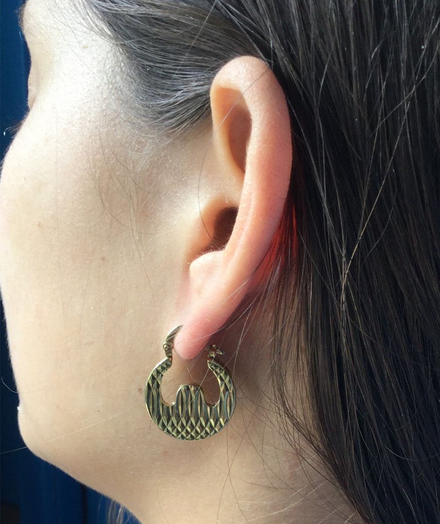 A pair of unique circular baggy earrings in brass, available in silver and gold finishes, showcasing a modern design.