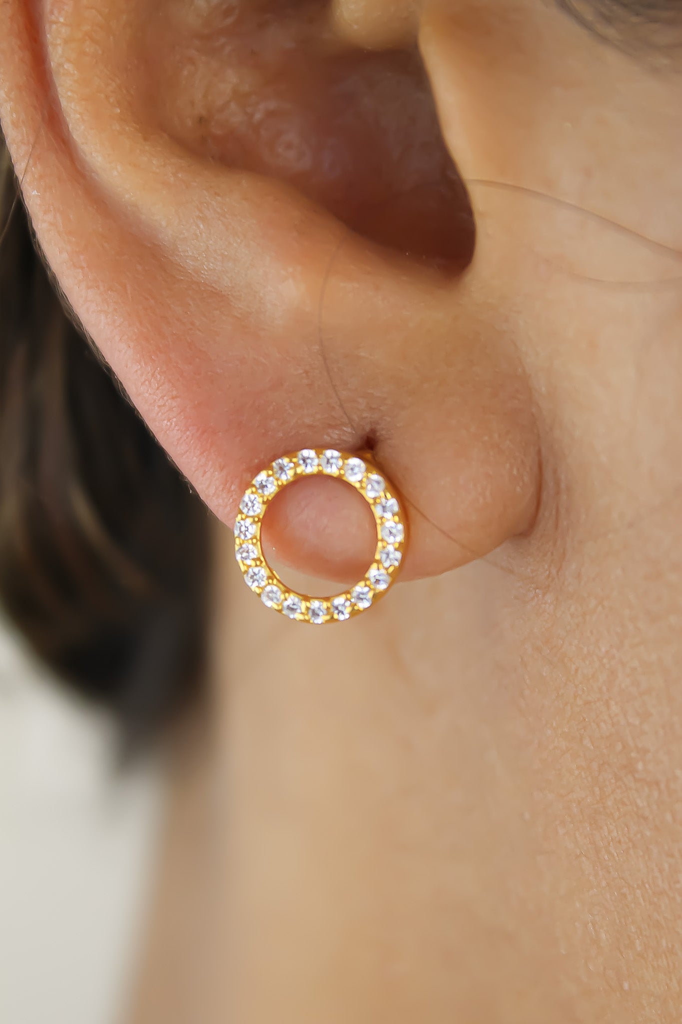 Elegant 18K gold-plated circle earrings adorned with sparkling zirconia stones, designed for pierced ears and hypoallergenic for sensitive skin.