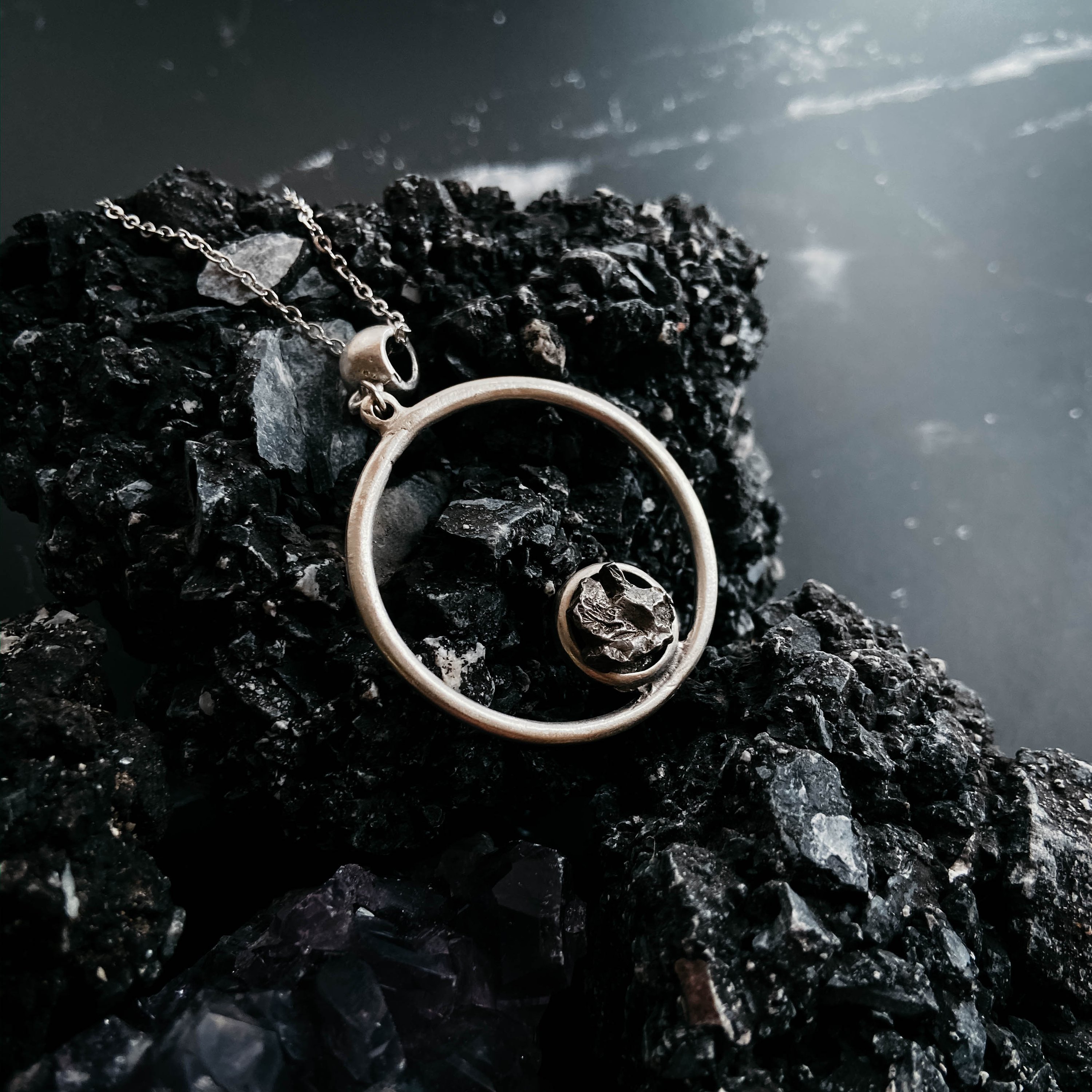 Circle Necklace featuring authentic raw Campo del Cielo meteorite, handcrafted with rhodium plated brass, showcasing a unique cosmic design.