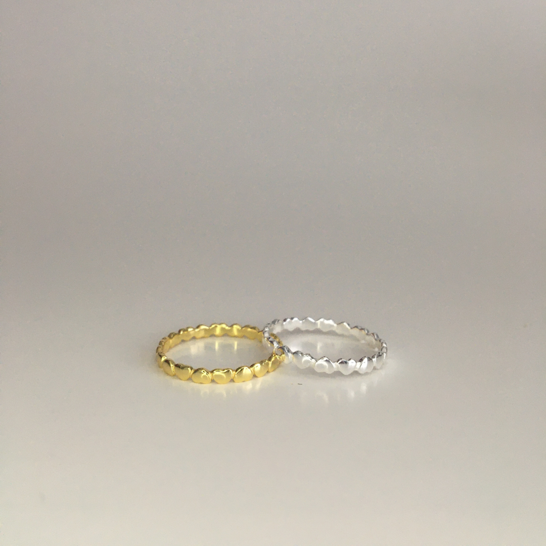 A delicate Circle of Love Ring made of sterling silver and gold, symbolizing love and support, displayed in an elegant anti-tarnish jewelry bag.